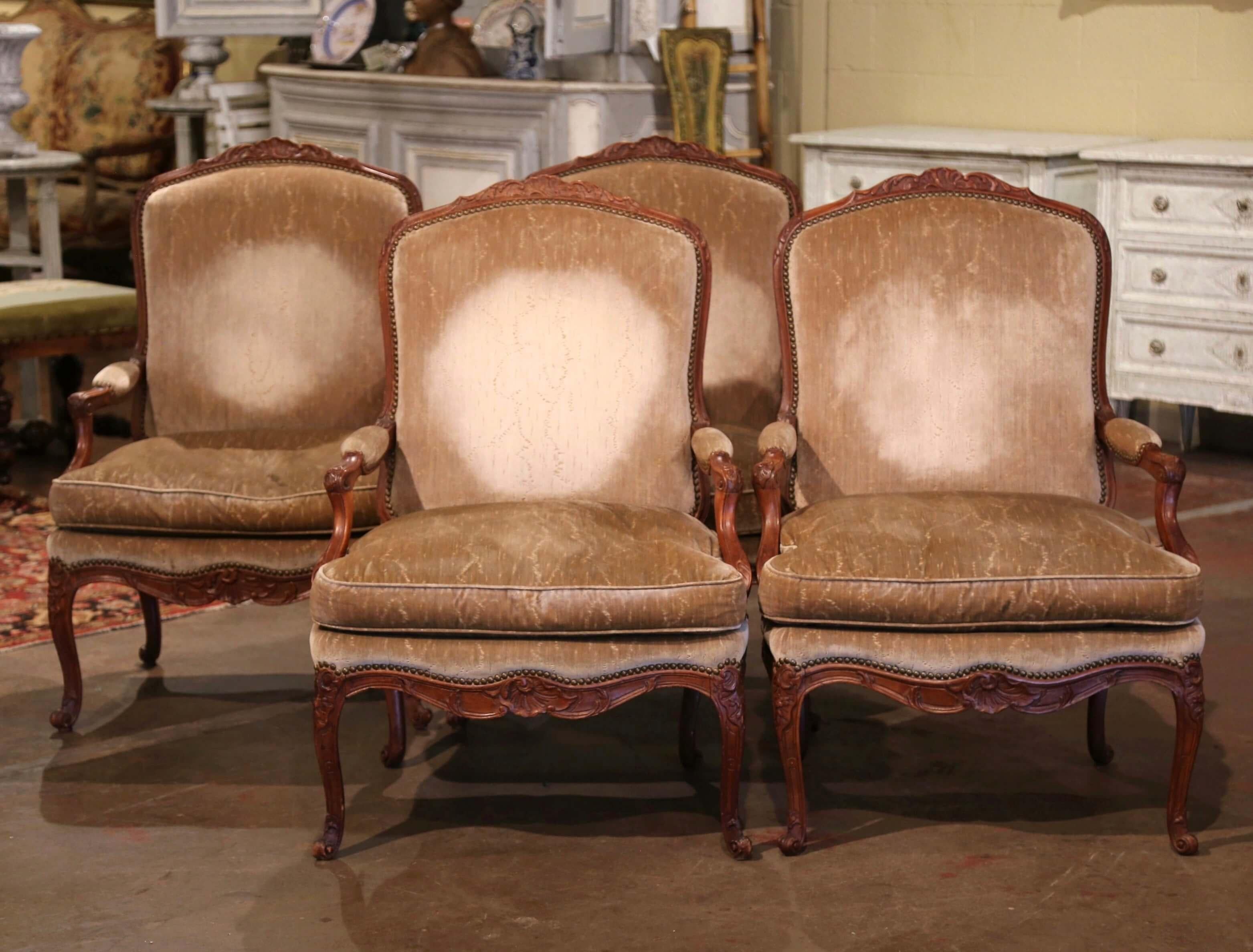 Decorate an office, study or a den with this elegant suite of four antique armchairs! Crafted in Provence, France circa 1880, each fauteuil stands on cabriole legs ending with escargot feet and decorated with hand carved floral motifs at the