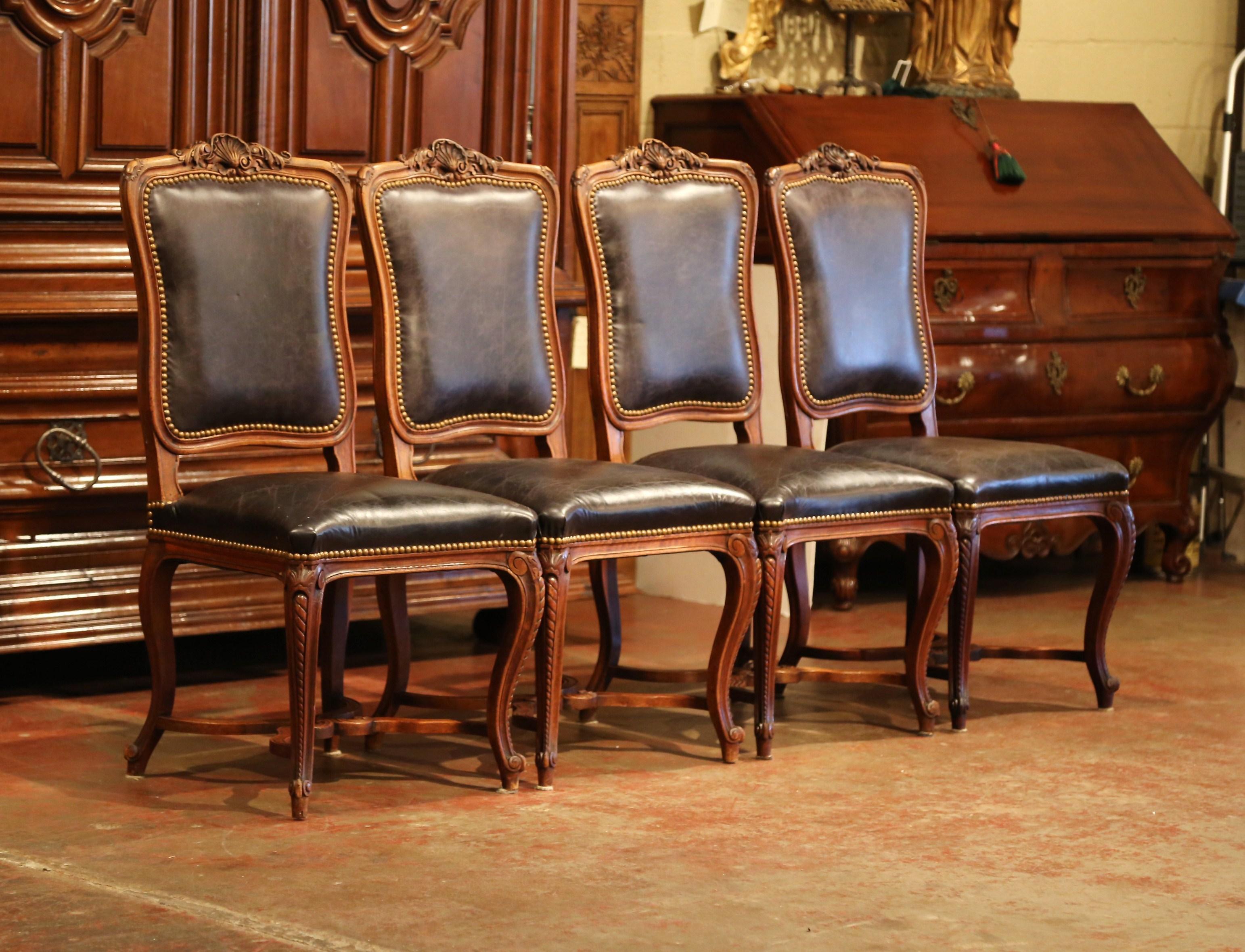 Place this traditional set of four chairs around a game table or in a small breakfast room. Crafted in France, circa 1880, each side chair sits on cabriole legs and has a bottom stretcher with hand carvings around the frame. The carvings include a
