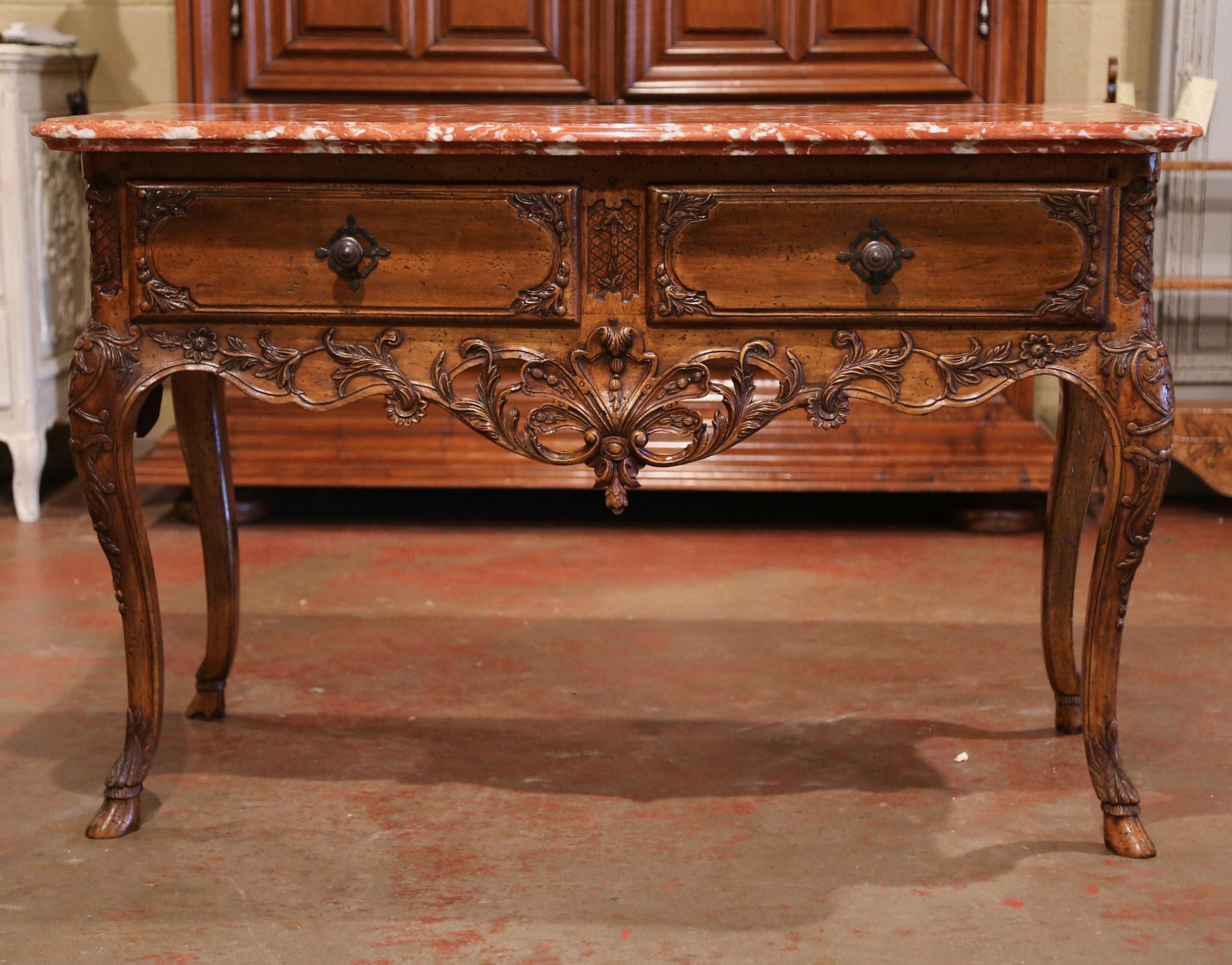 Decorate a living room with this elegant antique console table. Crafted in Provence circa 1890, the large fruit wood chest with bombe front and curved sides stands on four cabriole legs with carved sabot feet; it is decorated at the knees with