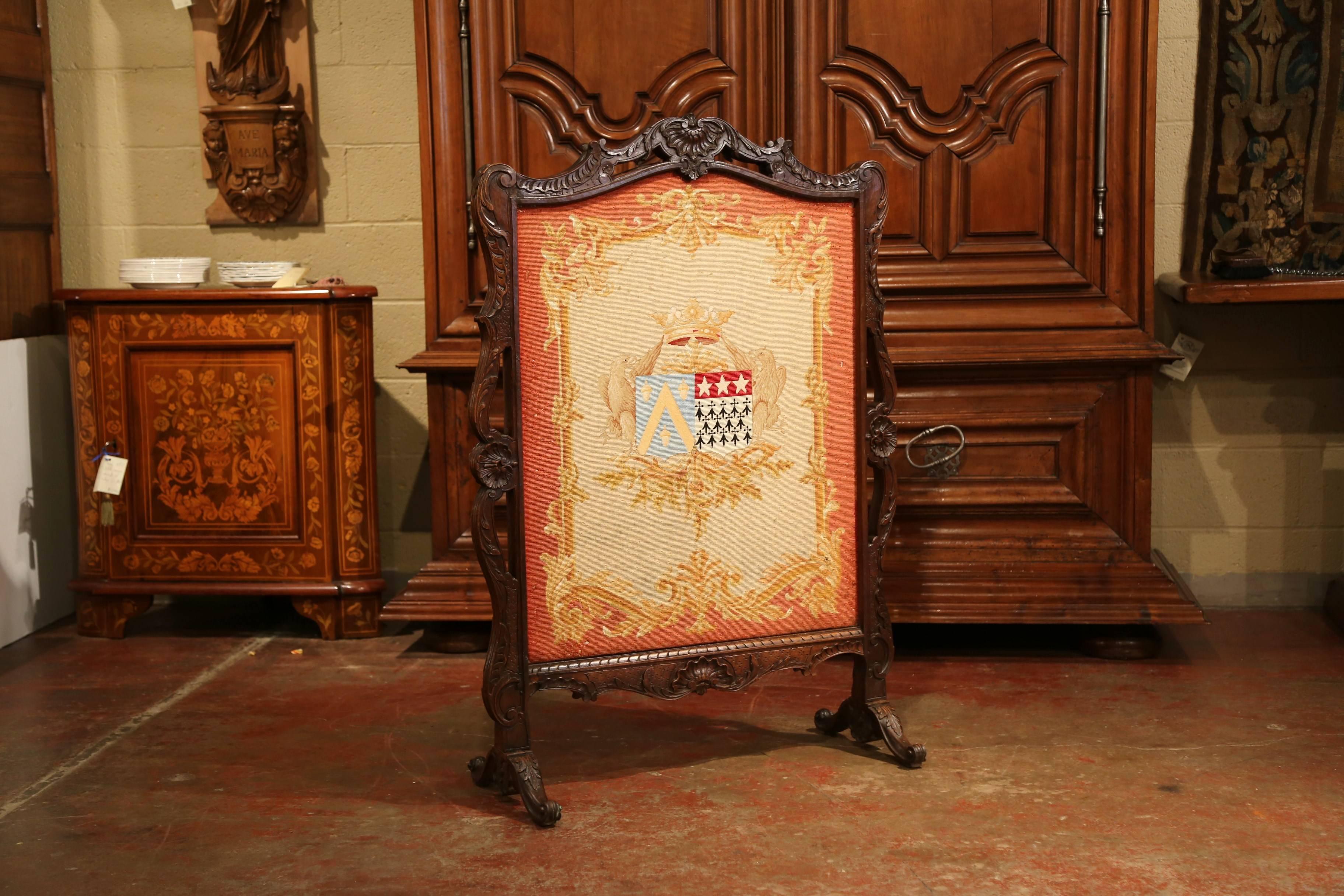 Place this elegant and colorful antique screen in front of your mantel! Created in France, circa 1870, the freestanding piece has a removable handwoven tapestry featuring a family coat of arms with crown and crest flanked by birds on each side. The
