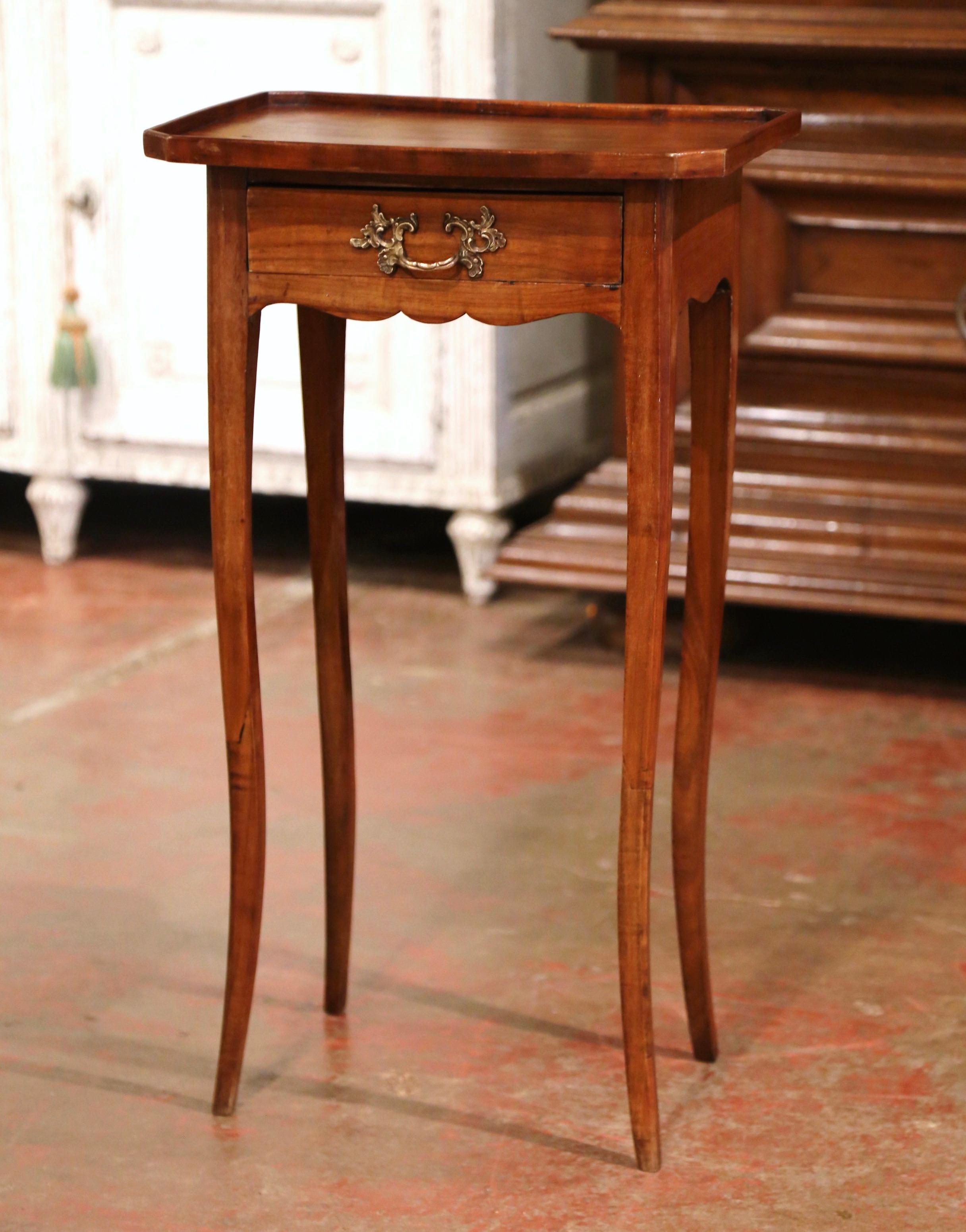 This small fruitwood antique end table would make a beautiful addition next to a sofa in a living room. Crafted in France, circa 1880, the fine side table stands on cabriole legs over a scalloped apron. The petite table is fitted with a small drawer