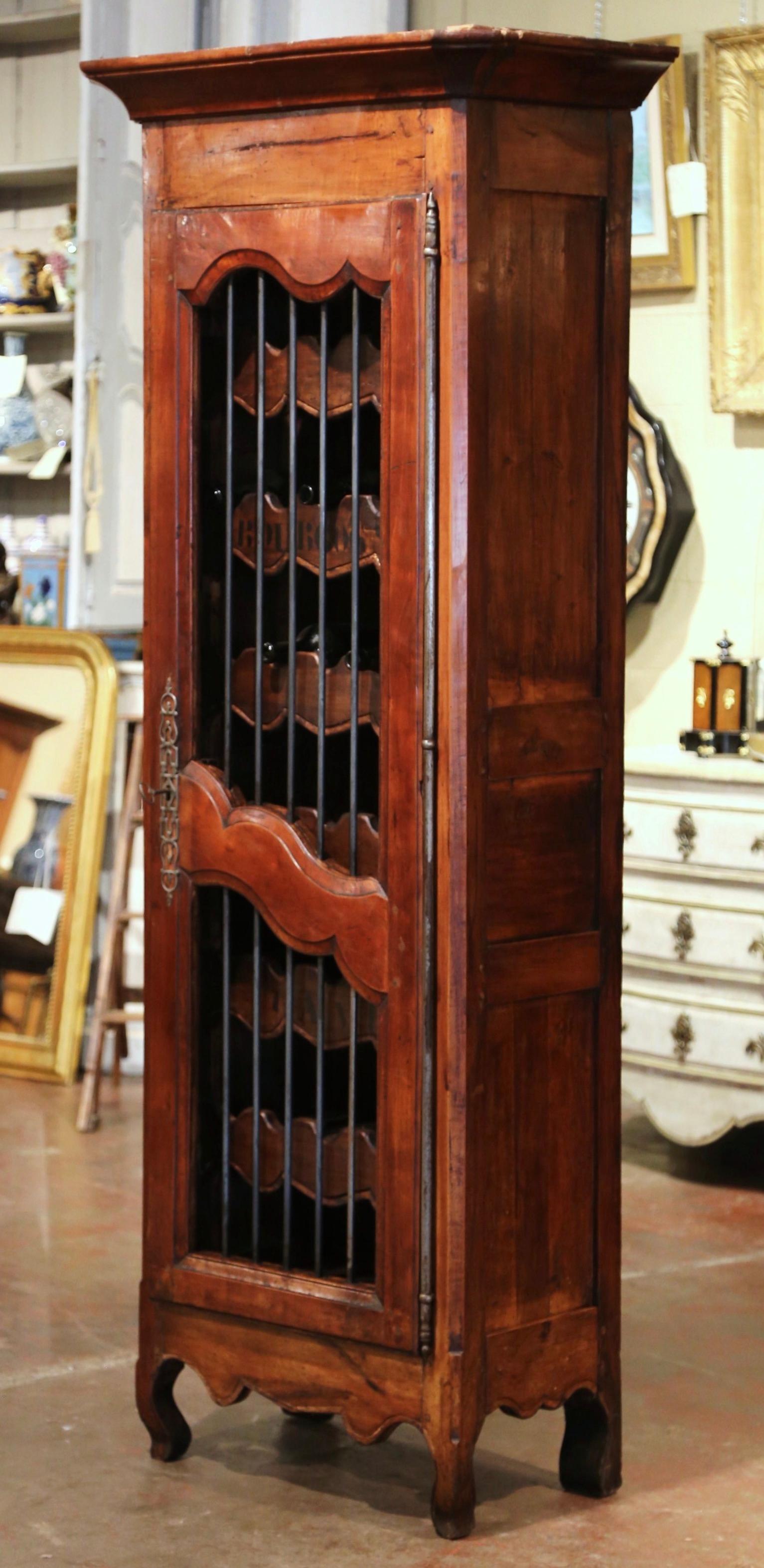 Keep your wine bottles locked and safe in this elegant antique display cabinet. Crafted in western France circa 1860, the bonnetiere stands on scrolled feet over a scalloped apron and has a top removable crown; the piece features a carved central