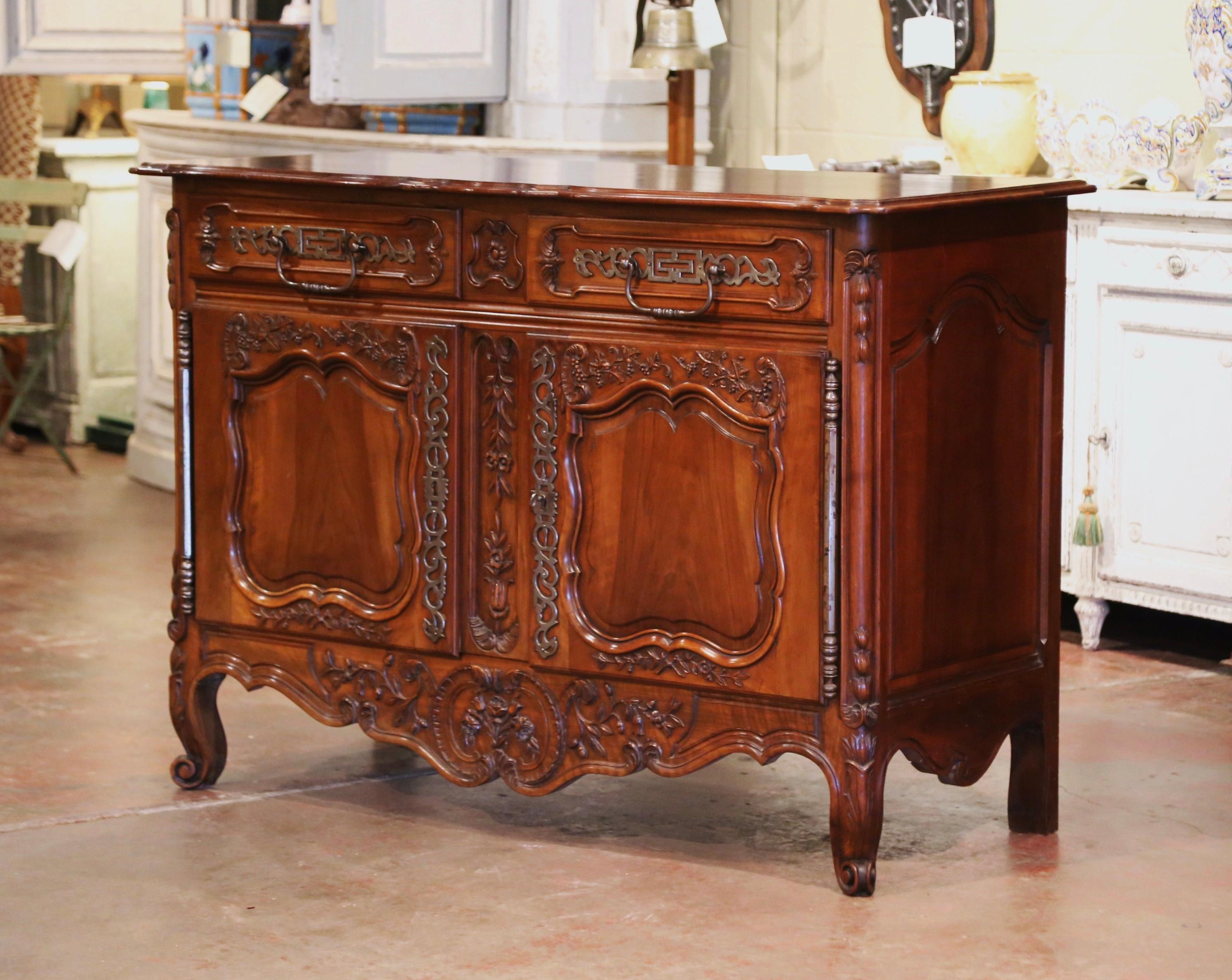 This elegant, antique fruit wood sideboard was carved in Southern France, circa 1880. The Classic cabinet exemplifies the Louis XV style with a heavy presence, dramatic lines and intricate floral and foliage carvings throughout. The cabinet stands