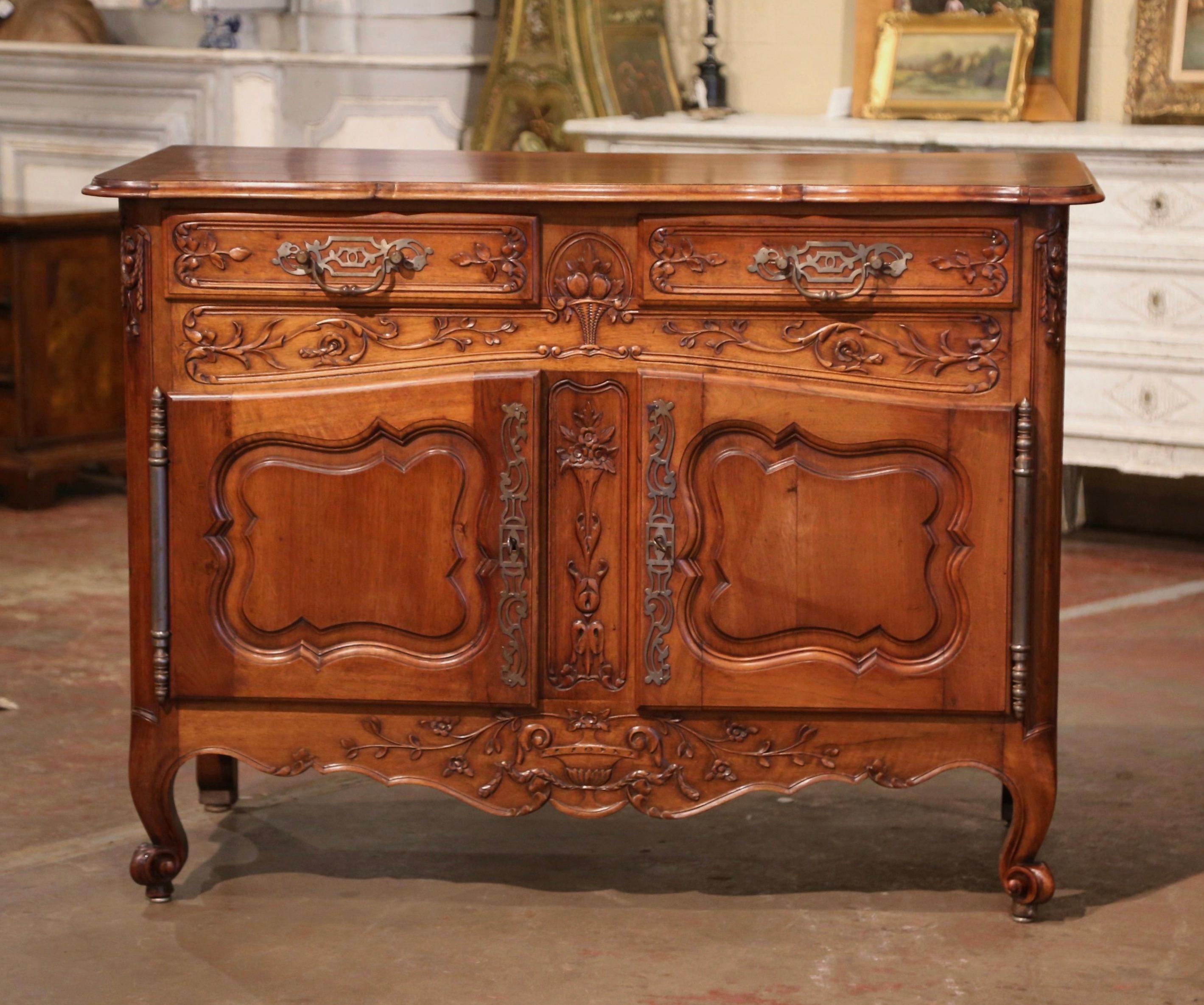 This elegant, antique fruit wood sideboard was carved in Southern France, circa 1890. The Classic sideboard exemplifies the Louis XV style with a heavy presence, dramatic lines and intricate floral and foliage carvings throughout. The cabinet stands