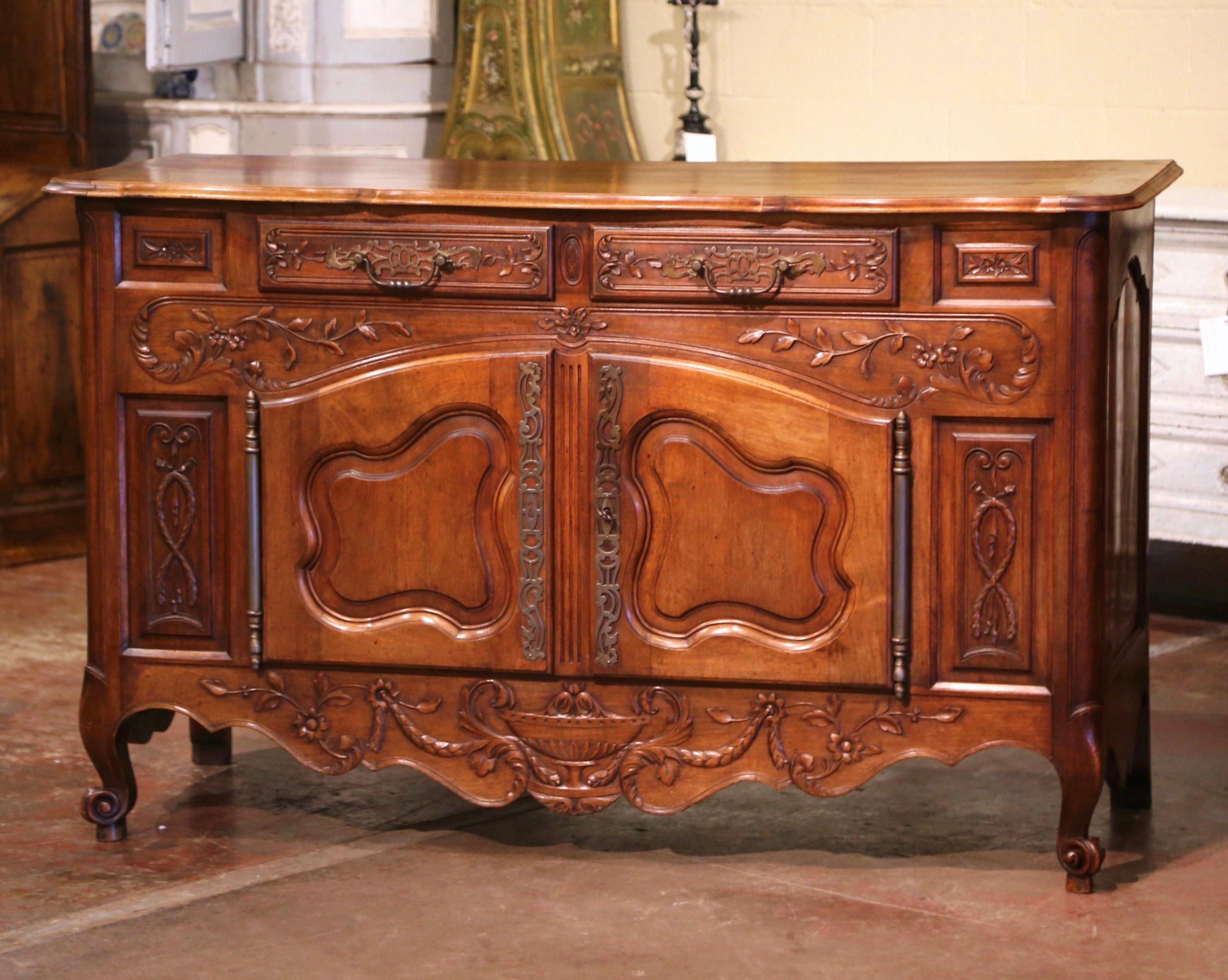 This elegant, antique fruit wood sideboard was carved in Southern France, circa 1880. The Classic sideboard exemplifies the Louis XV style with a heavy presence, dramatic lines and intricate floral and foliage carvings throughout. The cabinet stands