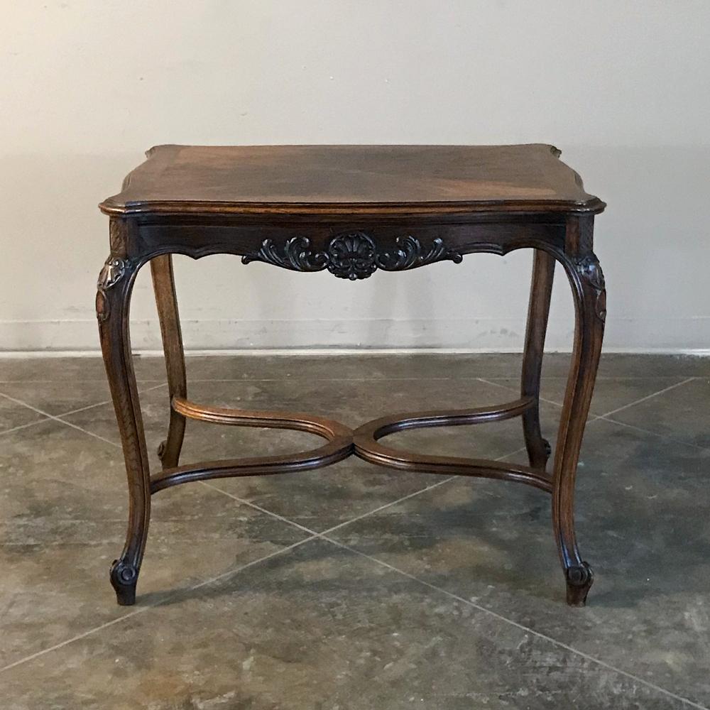 19th century French Louis XV end table features gracefully scrolled cabriole legs and apron, the latter of which has been lavished with hand carved shell and foliate motifs. Double lyre stretchers add elegant support below, with a radial pattern in