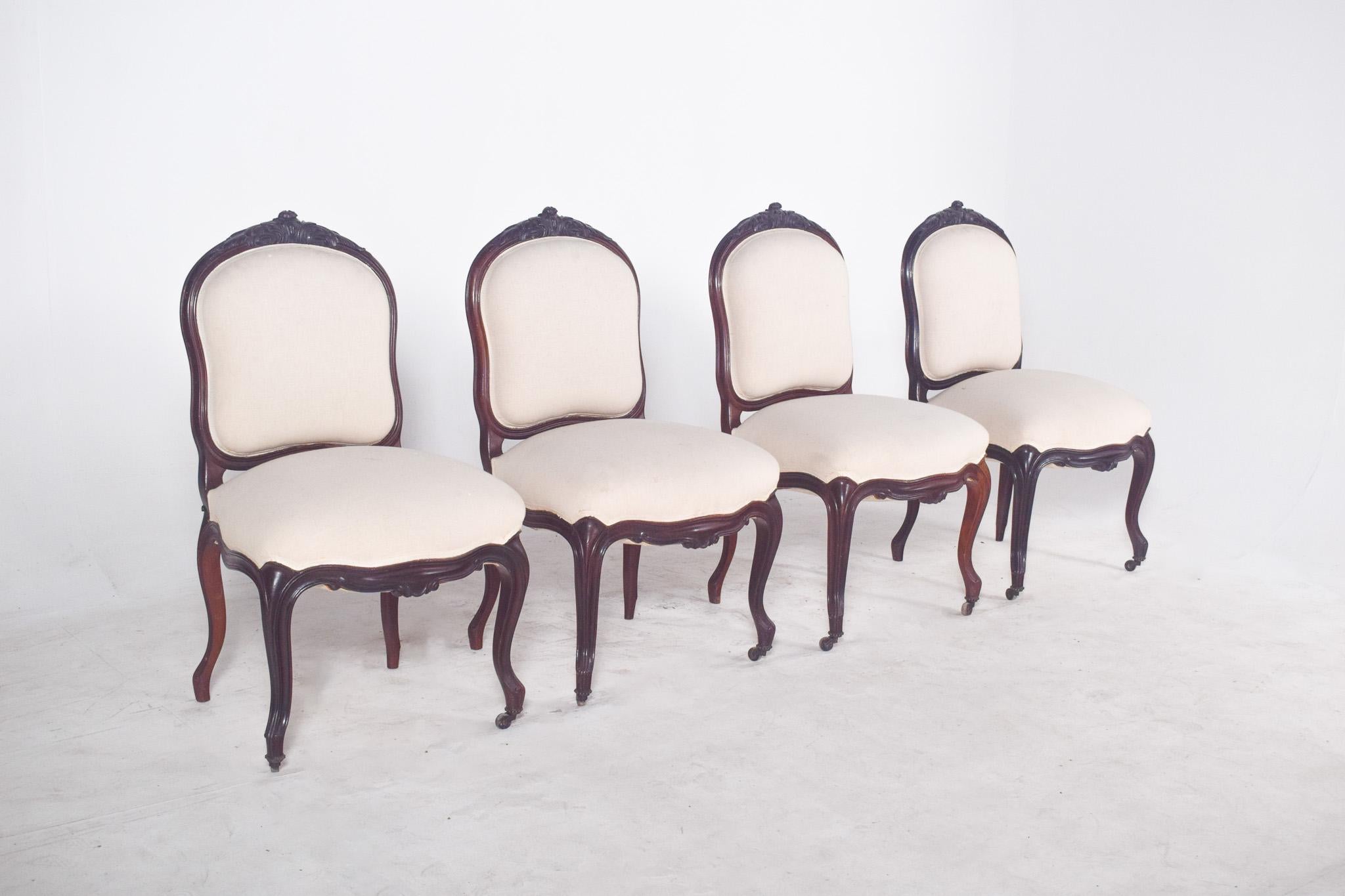 Cuatro sillas de palisandro. Marcos de madera noble oscura ricamente tallados, especialmente visibles en la parte superior del respaldo y en las patas cabriolé. Probablemente de la segunda mitad del siglo XIX, estas sillas combinan elegancia y
