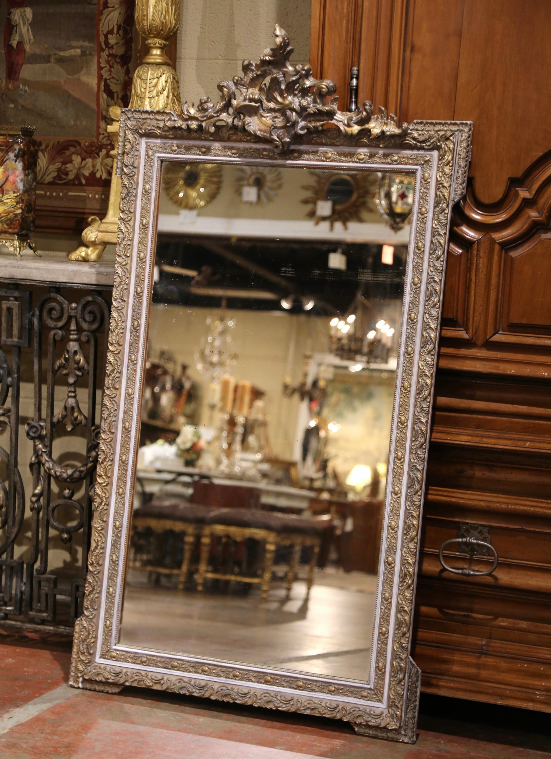 Décorez une salle d'eau ou une entrée avec cet élégant miroir antique peint en doré ! Fabriqué en France vers 1870, le fronton ajouré et orné présente un cartouche de feuilles d'acanthe tourbillonnantes, flanqué de feuilles et d'un décor floral sur