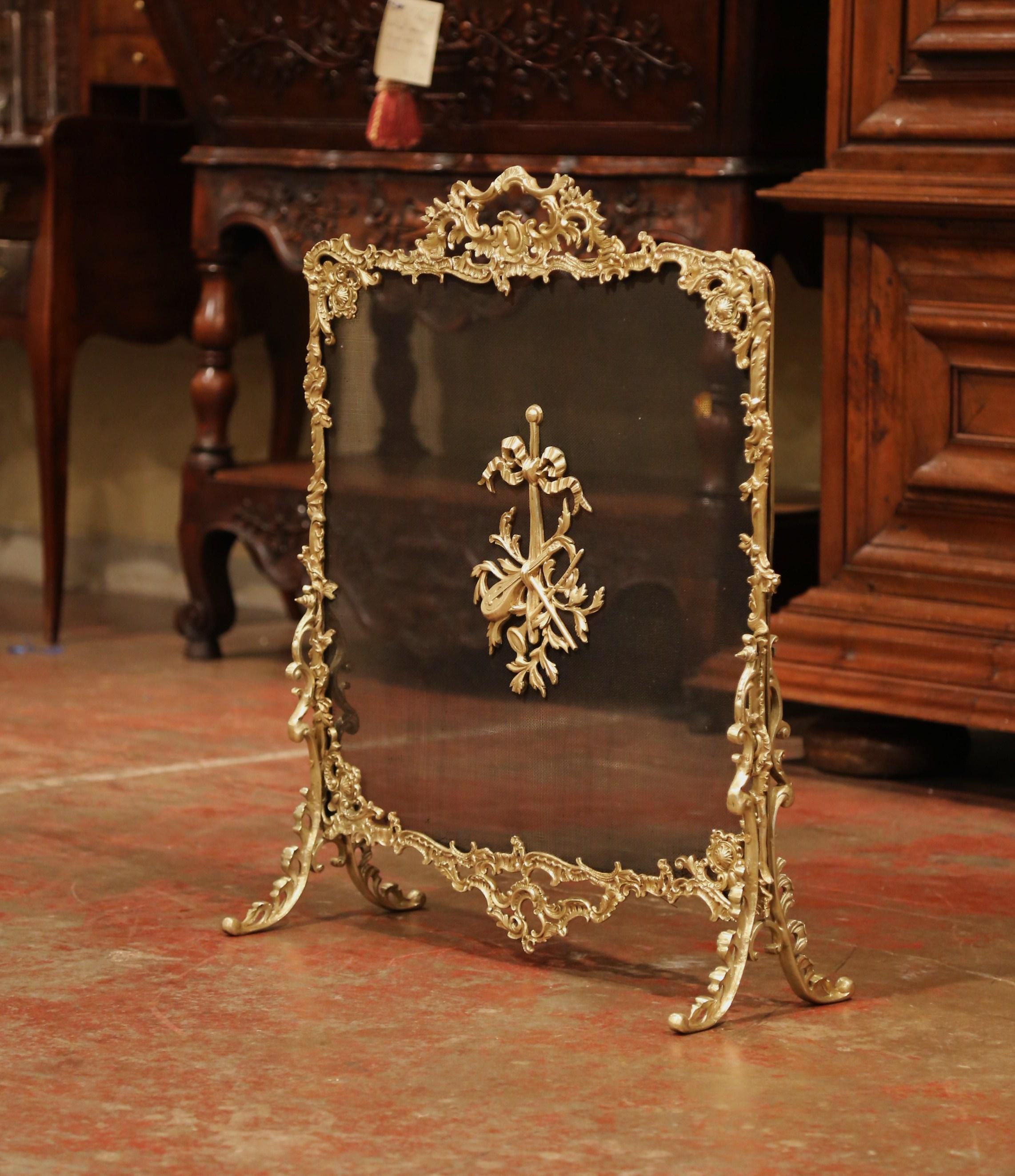 Decorate your fireplace with this antique Rococo bronze doré screen from France. Crafted circa 1870, the cartouche shaped screen sits on four scroll feet and features Louis XV motifs including asymmetrical foliage swaths with centre musical