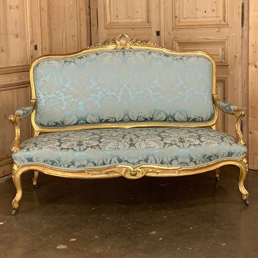 19th Century French Louis XV giltwood canape or sofa displays the grandeur and opulence of the Rococo style during one of its revivals of the Napoleon III era. The gracious, naturalistic form so favored by King Louis XV has been aptly expressed in