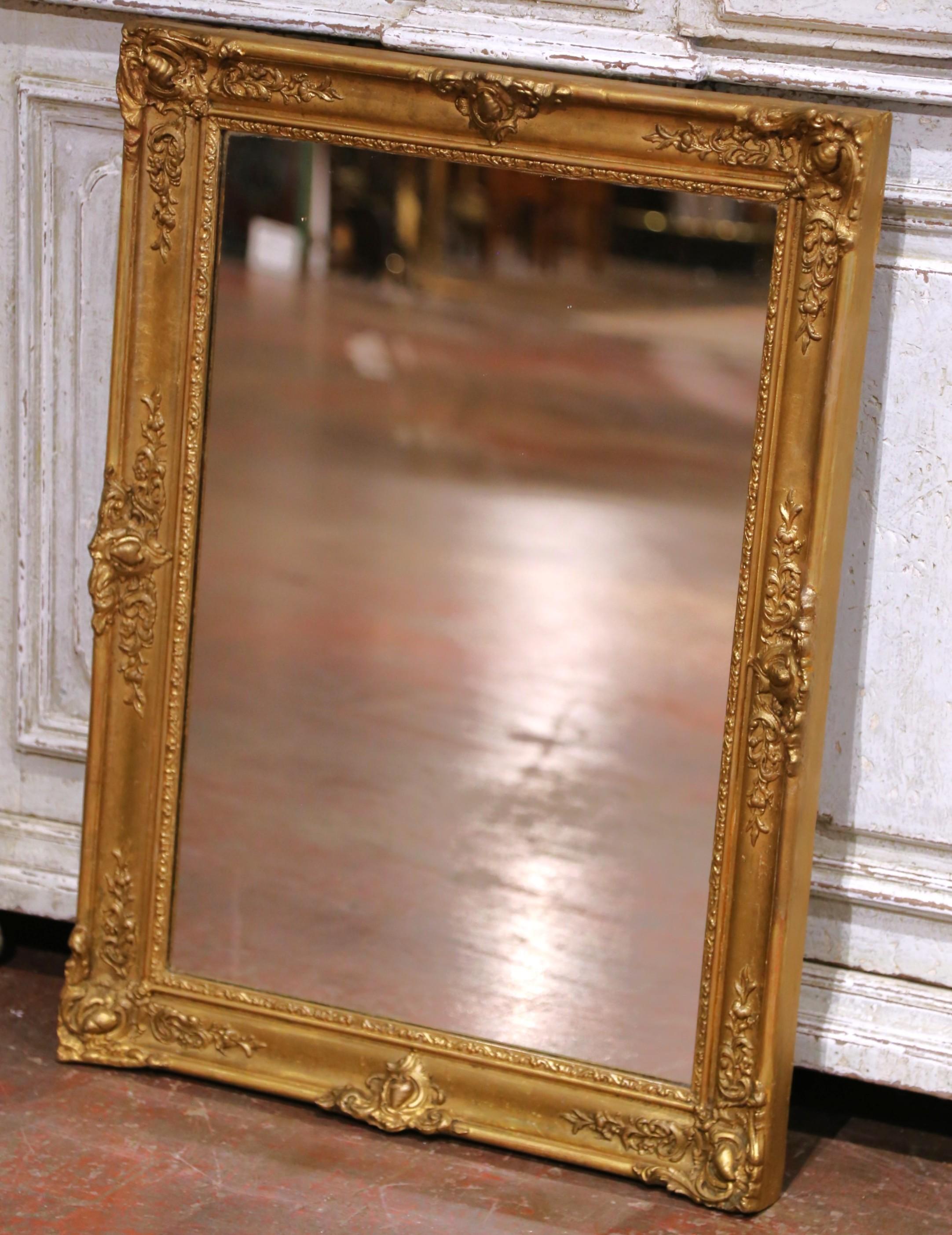 Eleganza per un ingresso, uno spogliatoio o un corridoio con questo elegante specchio antico in legno dorato realizzato in Francia intorno al 1880 e modellato in stile Luigi XV. La cornice rettangolare presenta motivi rococò riccamente intagliati e