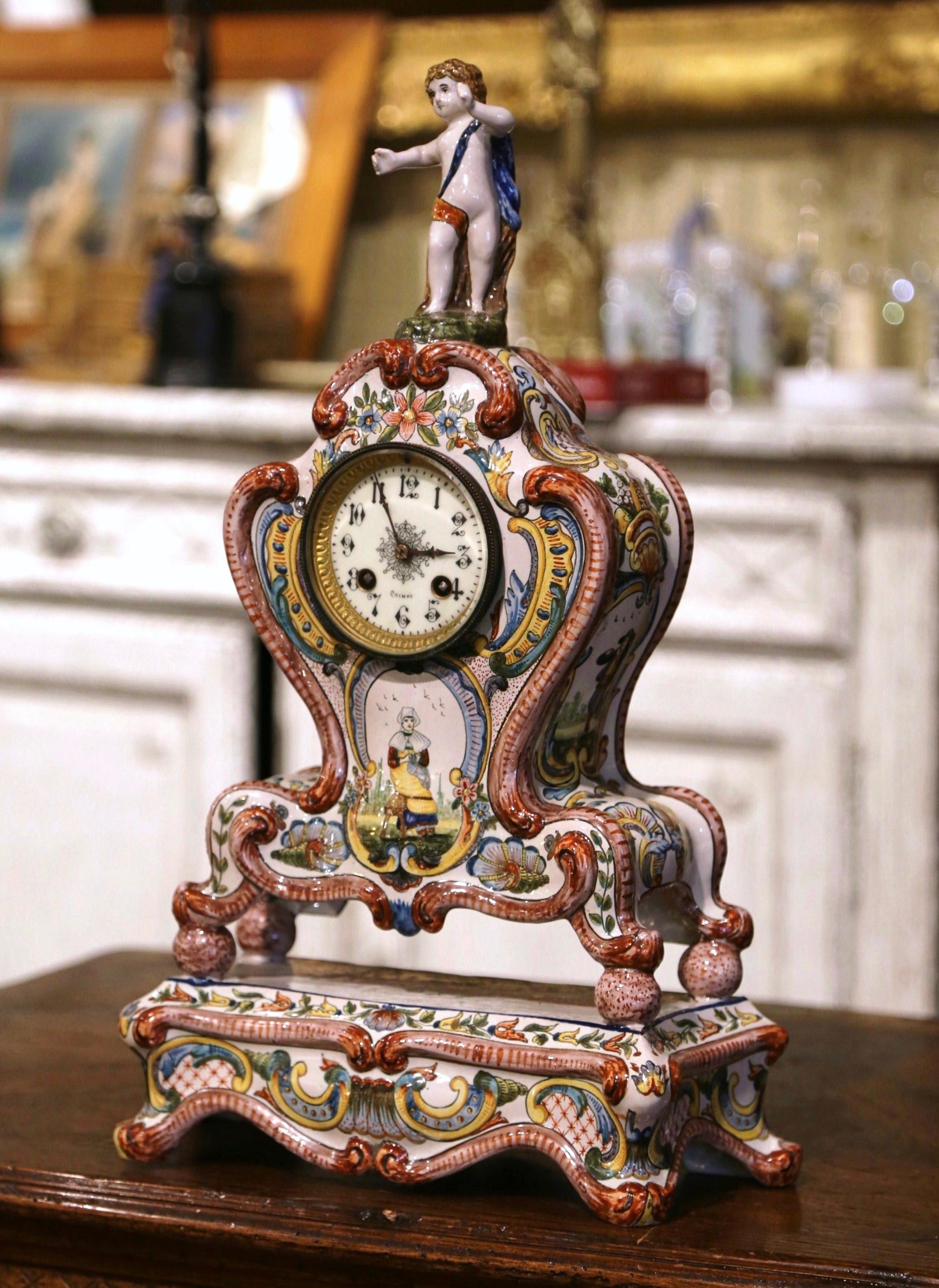 Décorez une cheminée ou une étagère avec cette horloge ancienne élégante et colorée. Fabriquée en Bretagne vers 1890, l'horloge en céramique repose sur une base attachée terminée par des pieds en volute, sur une façade en bombe avec un tablier