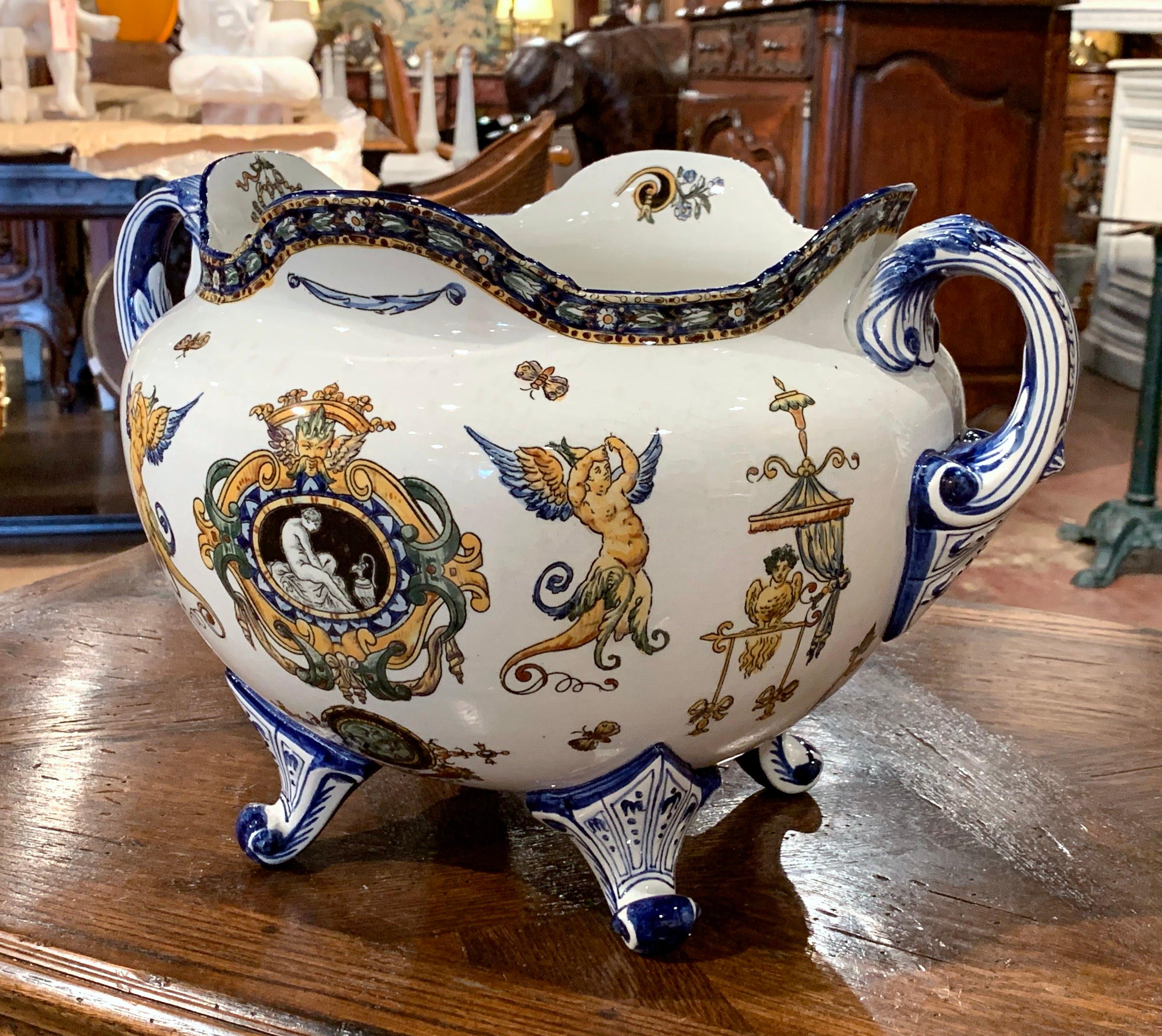 Decorate a table or a shelf with this elegant antique planter. Created in the “Faïencerie de Gien” France, circa 1890, the large cachepot is round in shape with a scalloped rim, two large handles and four curved feet. The ceramic planter is