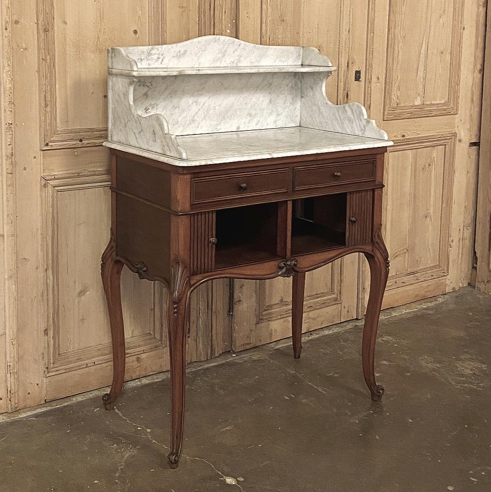 19th century French Louis XV mahogany marble-top washstand features graceful cabriole legs supporting the drawer tier atop which sits a bi-level Carrara marble top. Two drawers are situated above the cabinet doors below, which slide open in the