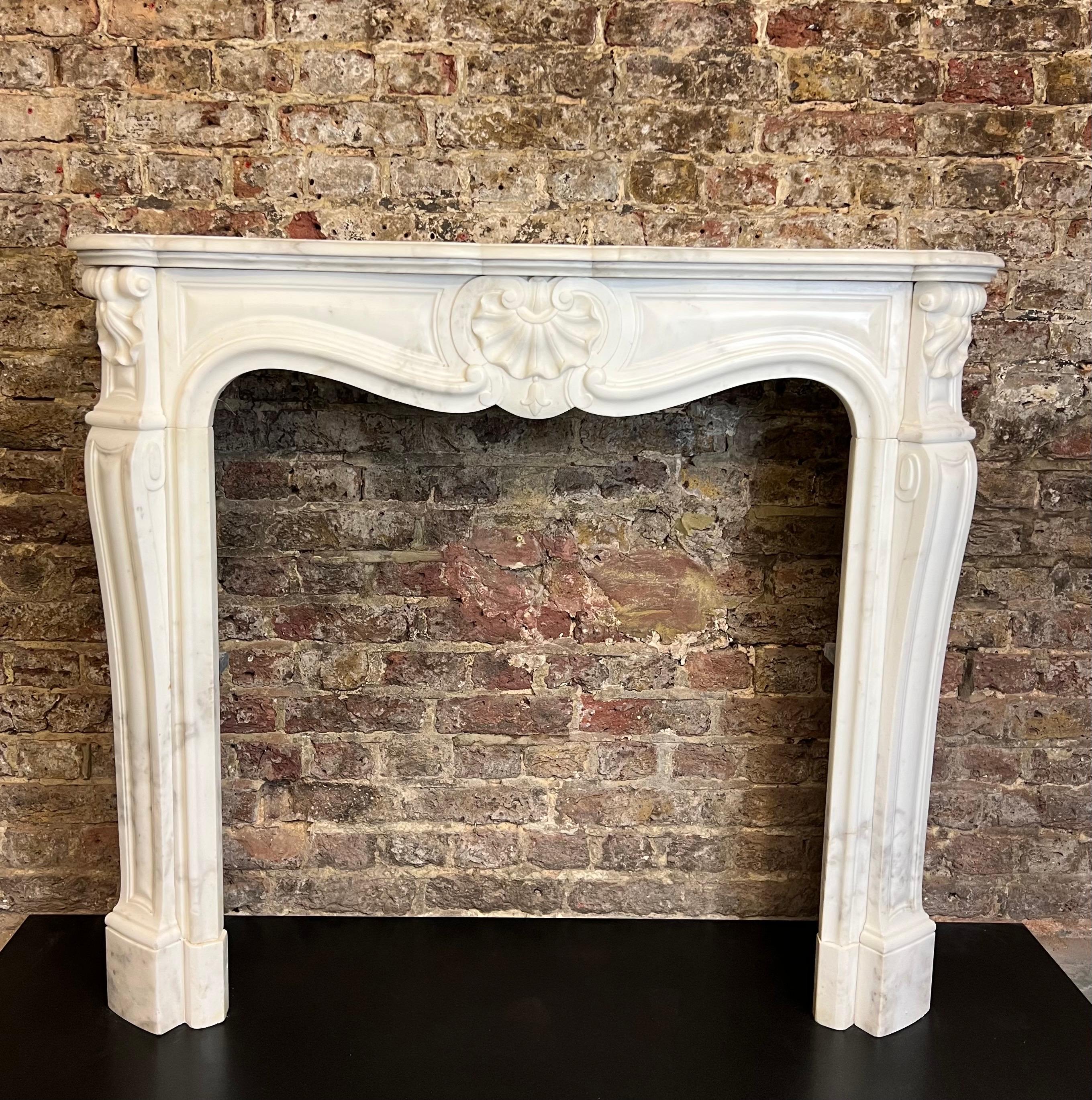 19th Century French Louis XV Marble Fireplace.
A Richly Hand Carved Louis XV Parisien Style Fireplace In White Carrara Marble. 
The Flowing Frieze With Carved Shell, Shaped Jambs With Scroll And Shell To Top,  
With Serpentine Swept Shaped Shelf.