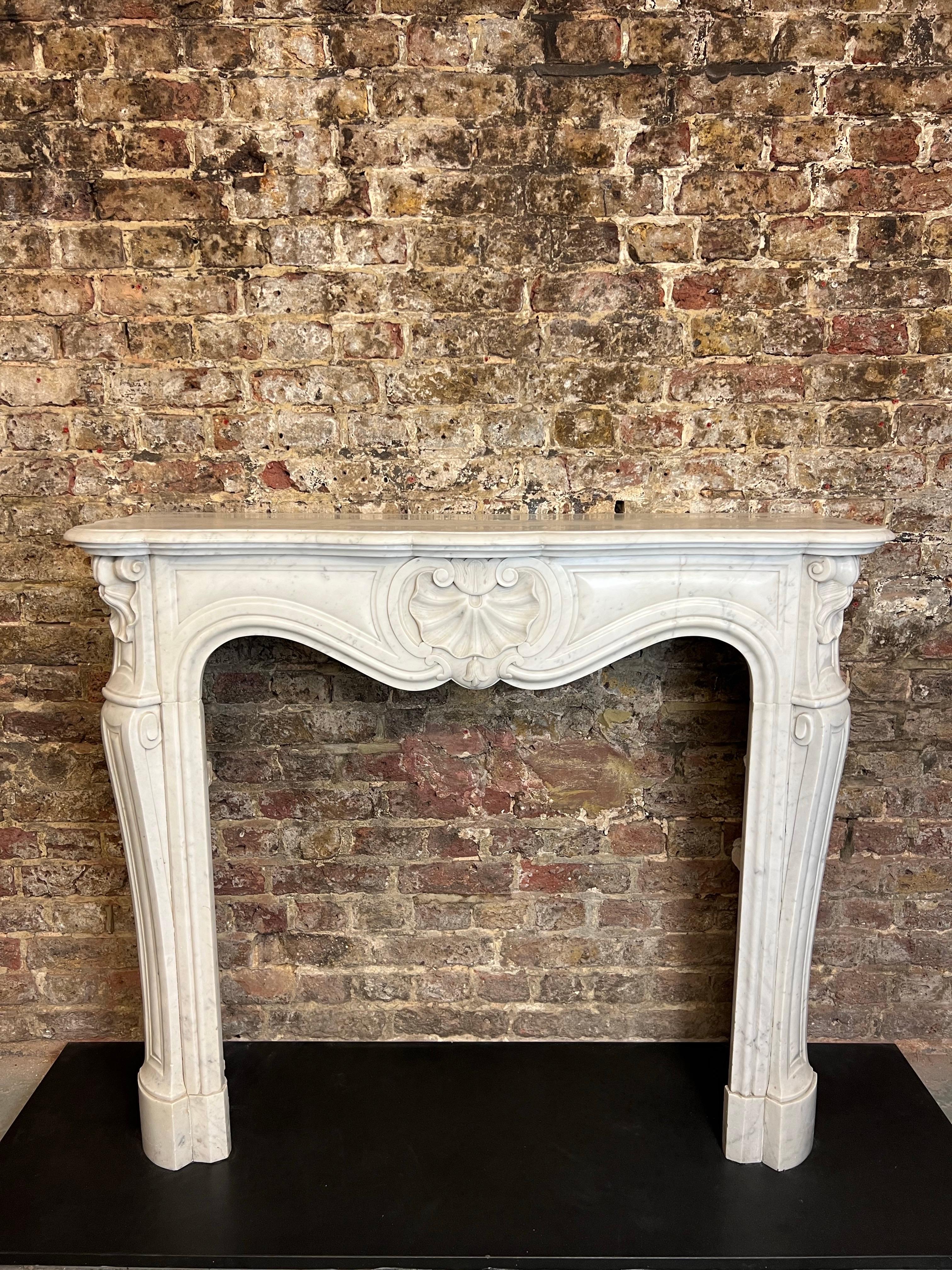 19th Century French Louis XV Marble Fireplace.
A Richly Hand Carved Louis XV Parisien Style Fireplace In White Carrara Marble. 
The Flowing Frieze With Carved Shell, Shaped Jambs With Scroll And Shell To Top,  
With Serpentine Swept Shaped Shelf.