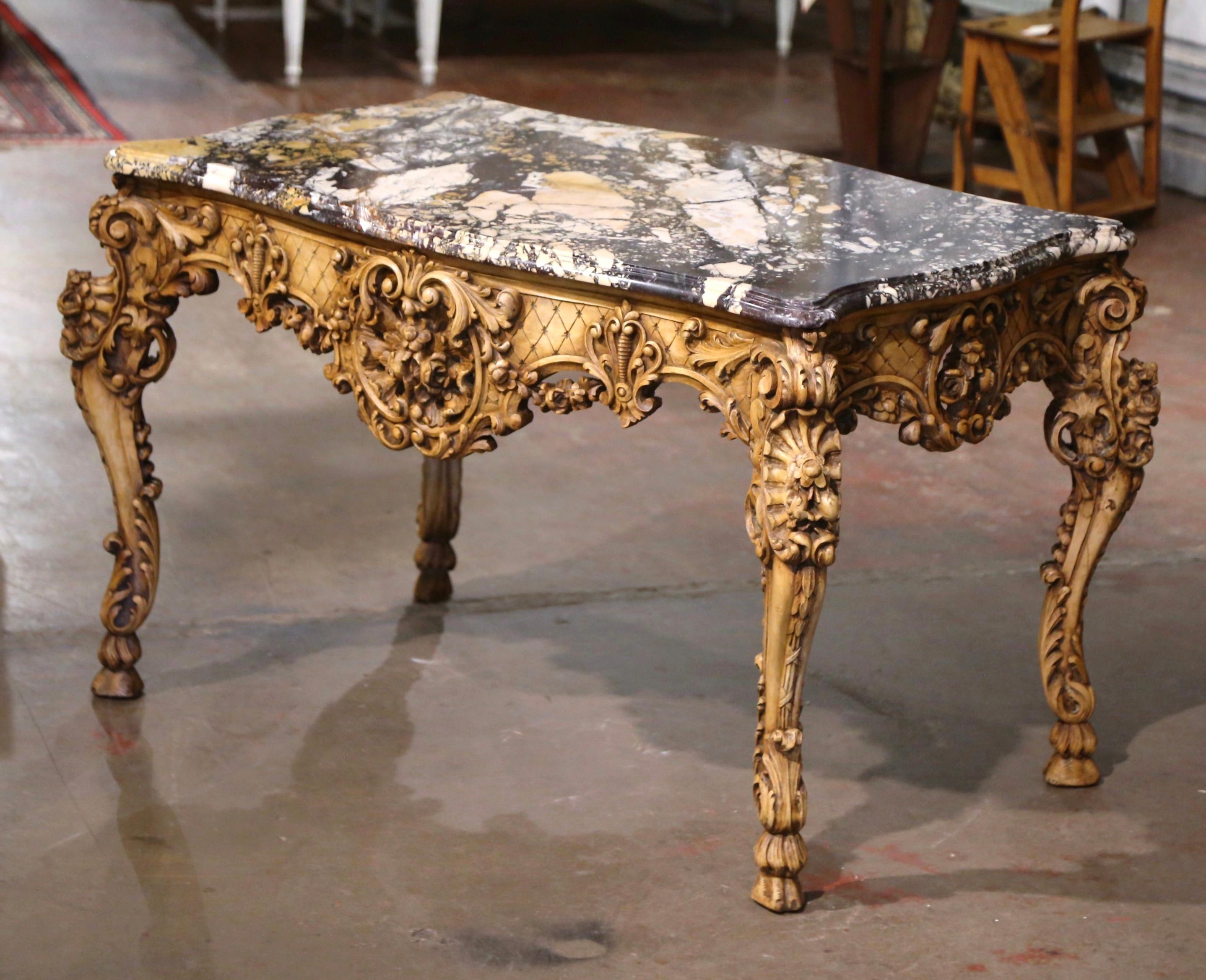 Decorate an entryway or a living room with this heavily carved antique center table. Crafted in Provence,  France circa 1870 and richly carved, the large table stands on elegant cabriole legs embellished with floral motifs at the shoulder, and