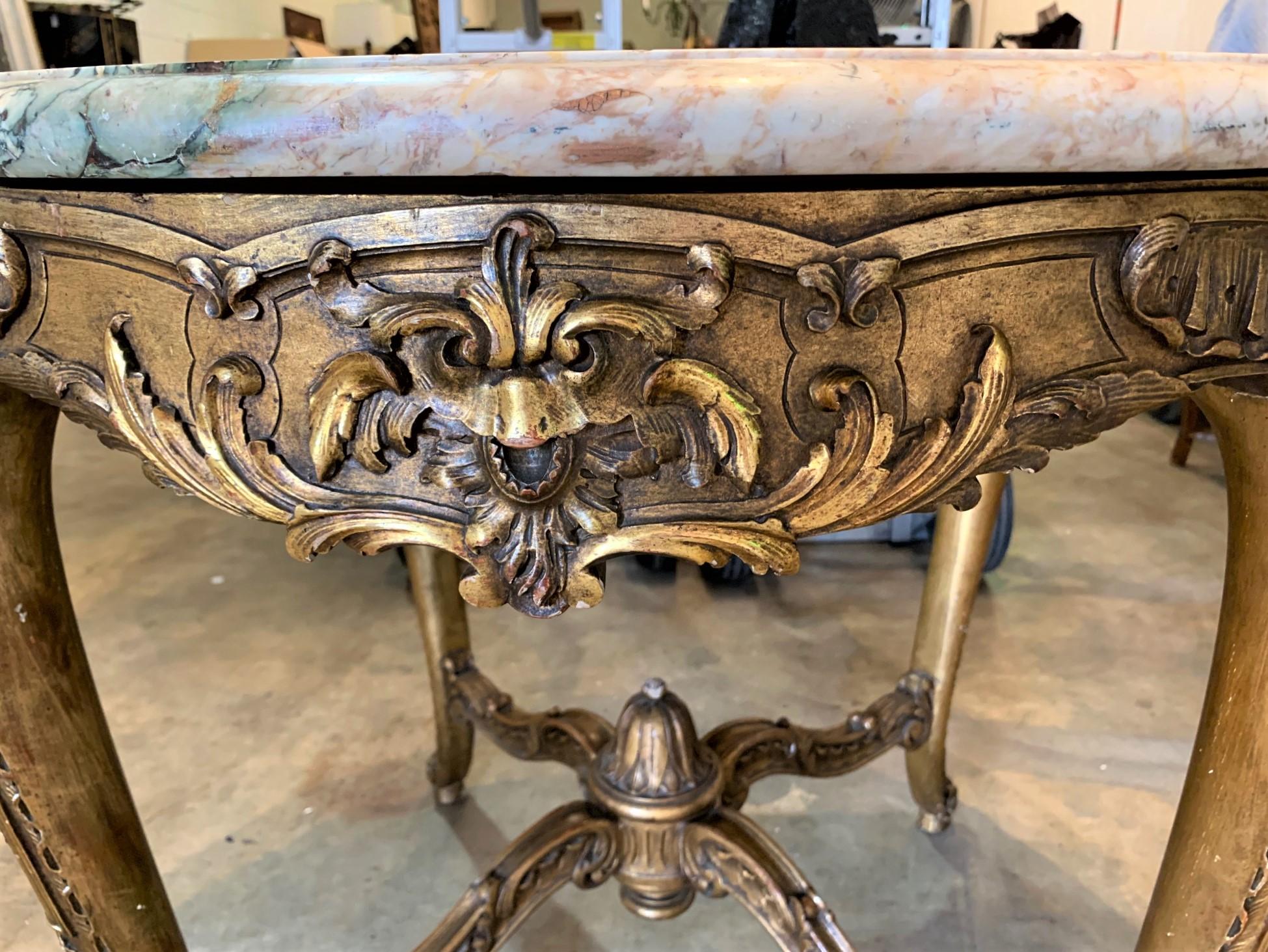 Exceptional 19th century French Louis XV style circular marble top center table. Crafted of giltwood and carved in a raised foliate motif. The elegant cabriole legs are joined by a nicely contoured cross-stretcher,

circa 1870.