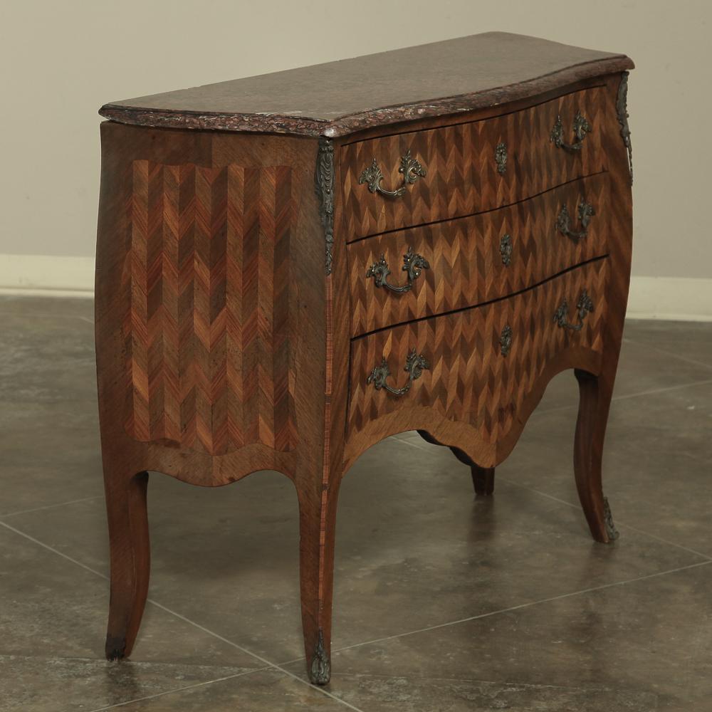 19th century French Louis XV marble-top Marquetry Bombe commode features an intricate inlay of mixed fine and exotic woods creating an art form known as marquetry. Three finely dovetailed drawers display a stunning geometric design repeated on the