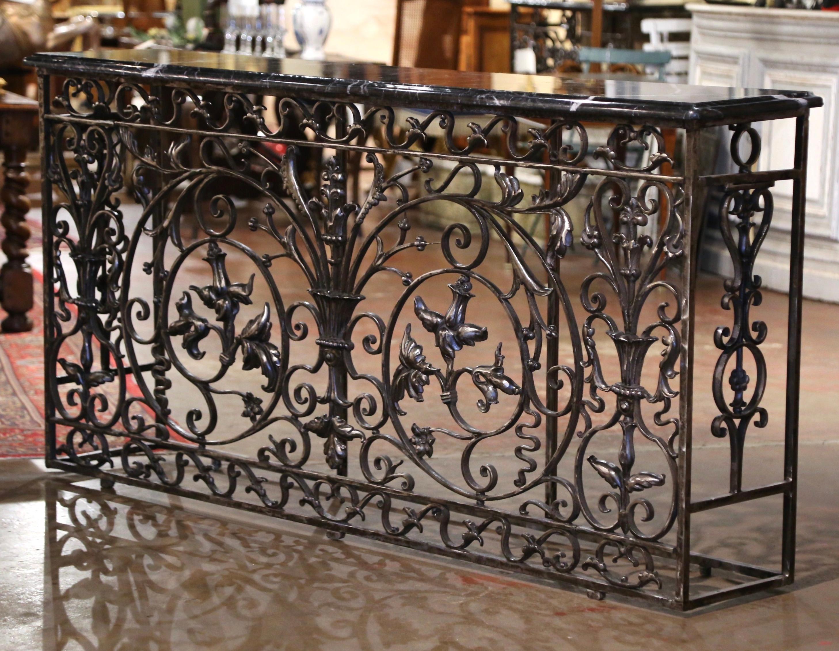 Forged in France circa 1860, the antique console table base stands on straight legs connected with an all around bottom stretcher. Long and narrow, the Louis XV style table features intricate scrolled decor on all three sides, embellished with a
