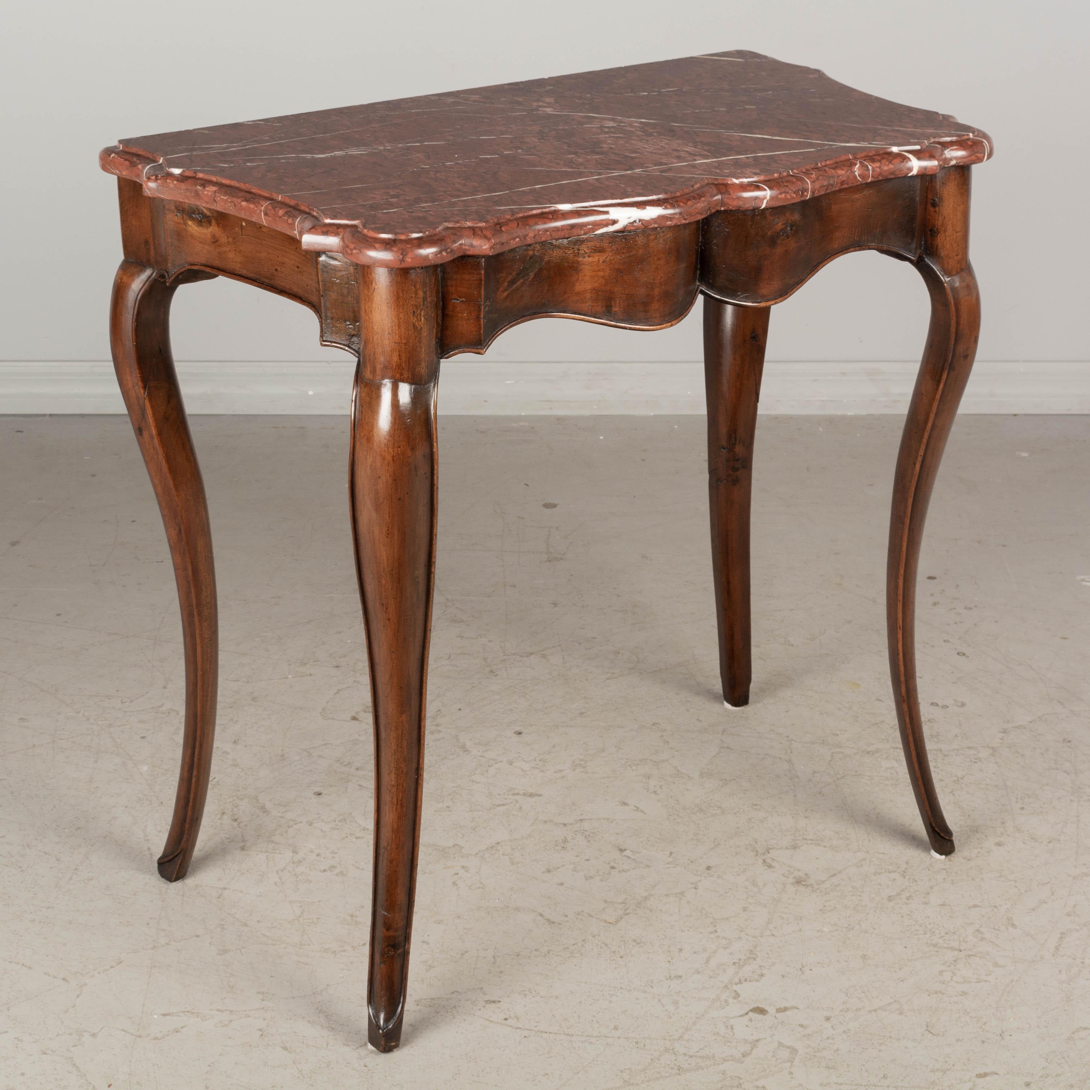 A 19th century French Louis XV style marble top walnut console table with arbalète front and cabriole legs ending in deer hoof feet. Original 1