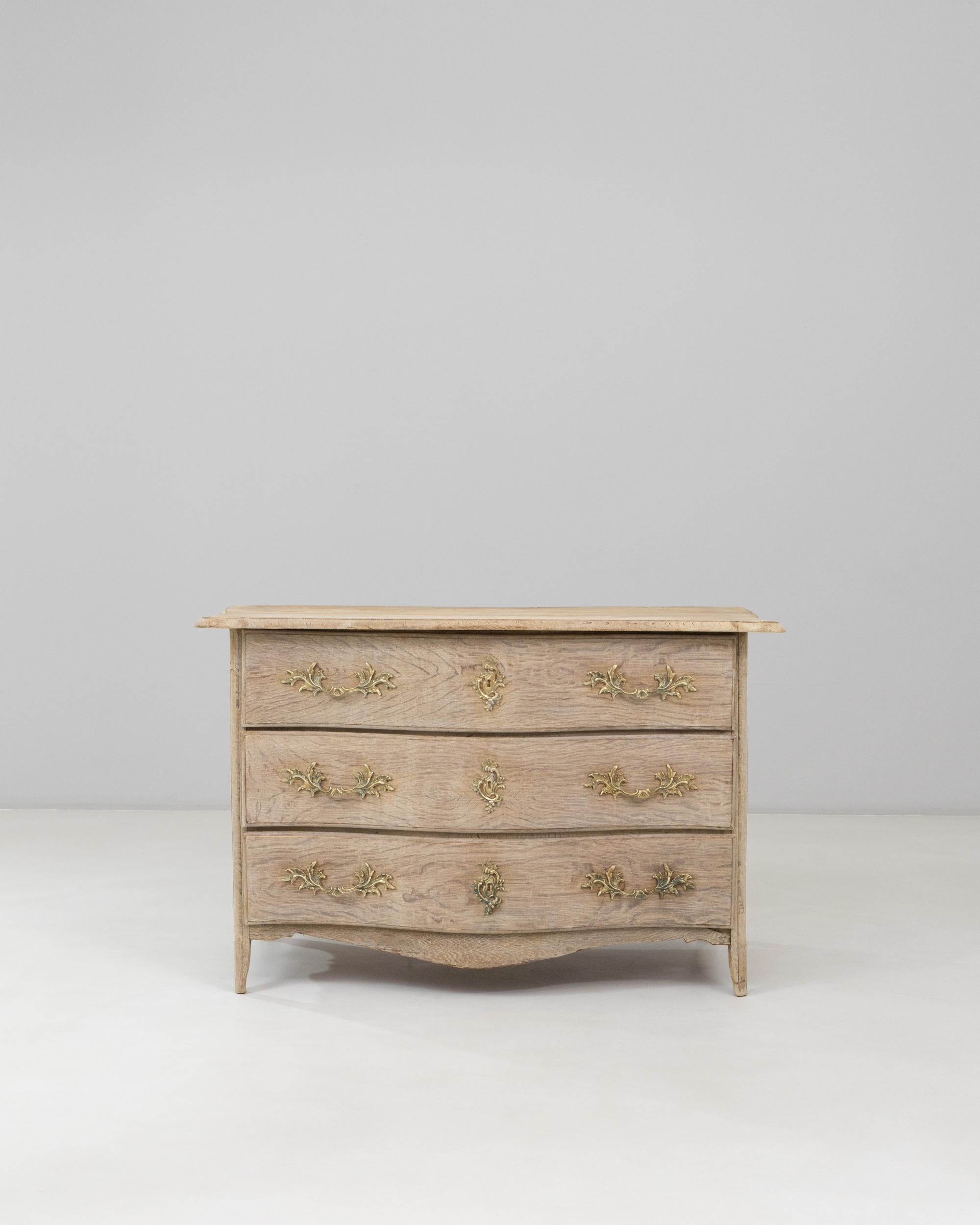 19th Century French Louis XV Oak Chest of Drawers. This elegant chest reflects the graceful curves and refined ornamentation characteristic of the Louis XV style. Crafted from solid oak with a softly weathered patina, it features a serpentine front