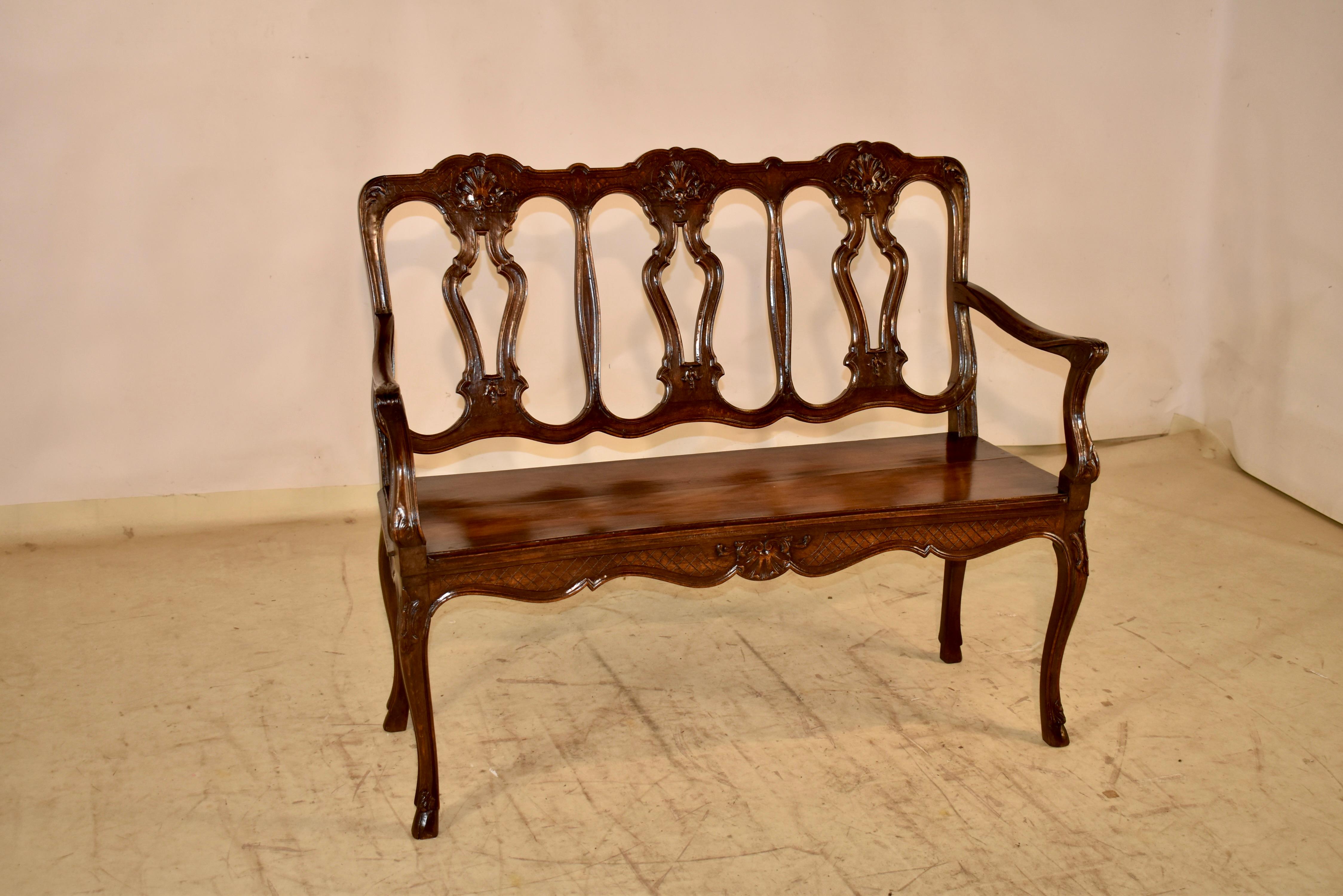 19th century hand carved oak settee from France in the Louis XV style.  The settee has a wonderfully detailed pierced back with three seats with shell hand carved decorations at the top central position over a pierced vase.  The  seat is nice and