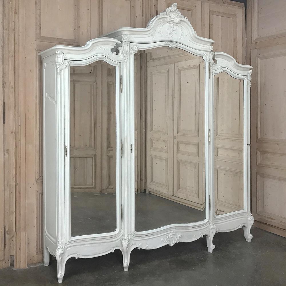 19th century French Louis XV Painted Triple Armoire features a triple compartment design with the center section stepped out in front for added storage and visual appeal from any angle! Arched crown undulates down to the shoulders of the shorter