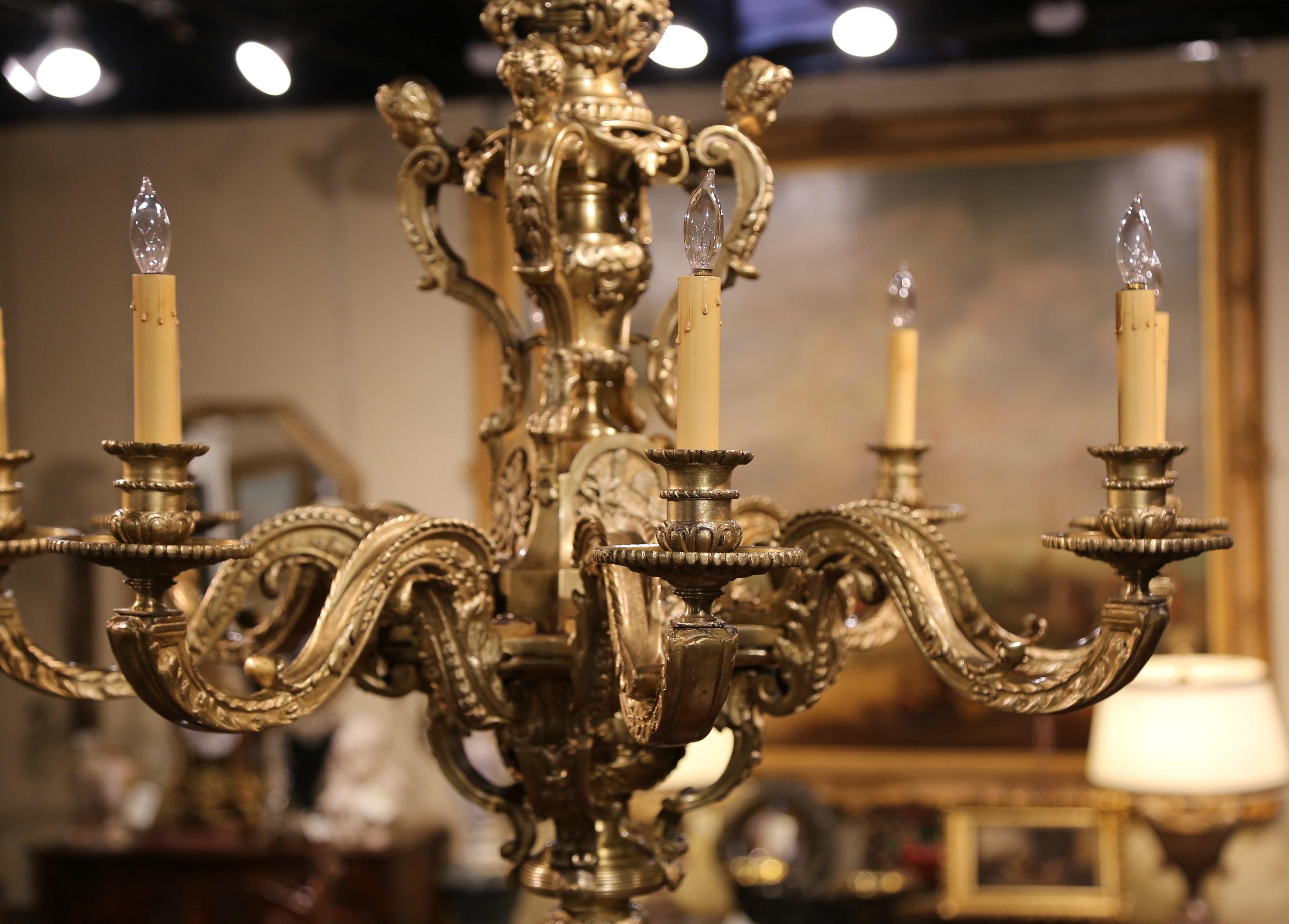 Crafted in France, circa 1880, the important chandelier features four cherubs on the upper part decorated with crossed torches, Fleurs-de-Lys, cartouche shapes, and angel faces with scrolled motifs. The eight-arm lights have been rewired to US