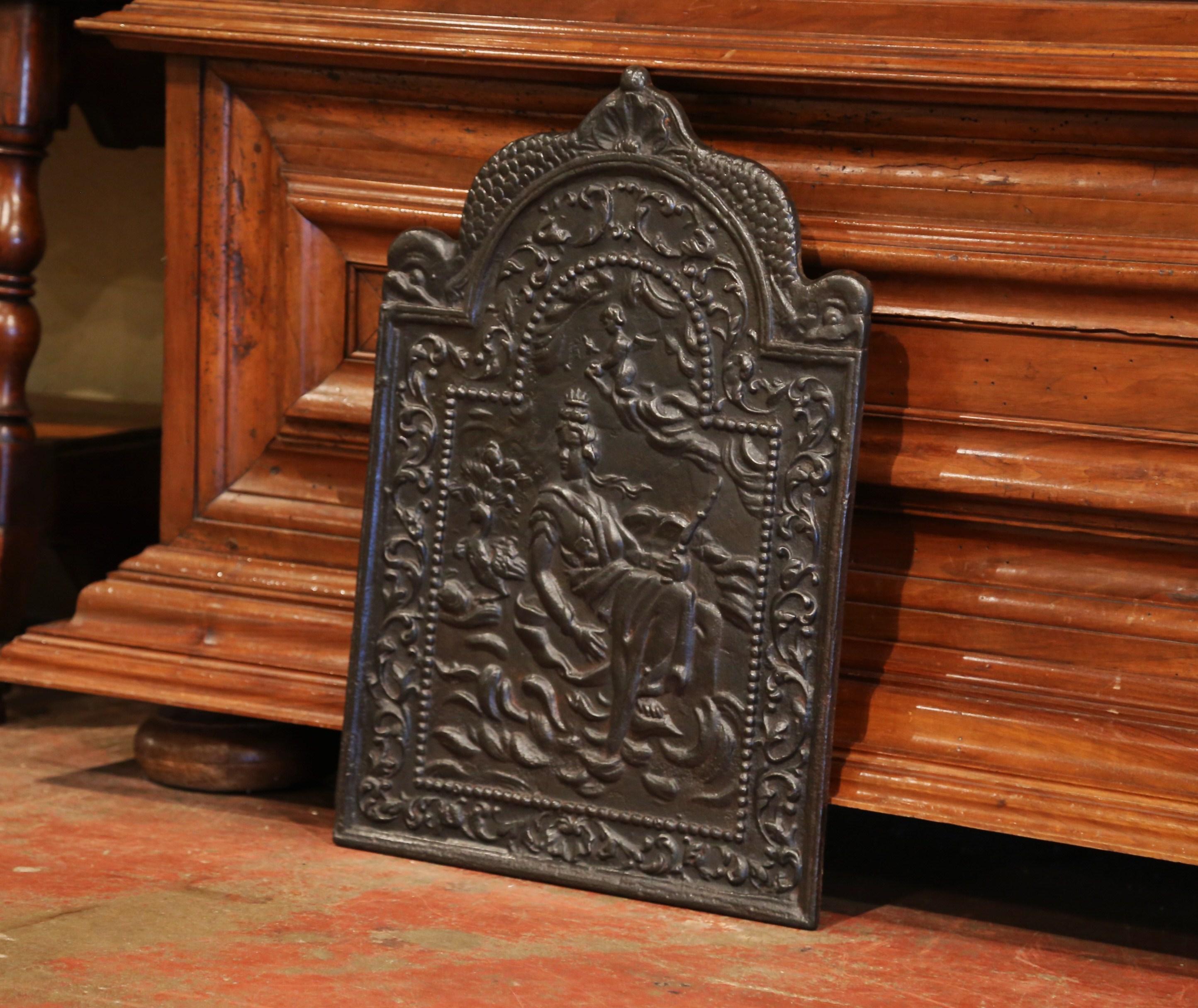 Use this fire back to decorate a fireplace or place it behind a stove in the kitchen. Crafted in France, circa 1860, the mythological iron plaque has an arched top flanked with dolphin figures on both sides. The central composition features a scene