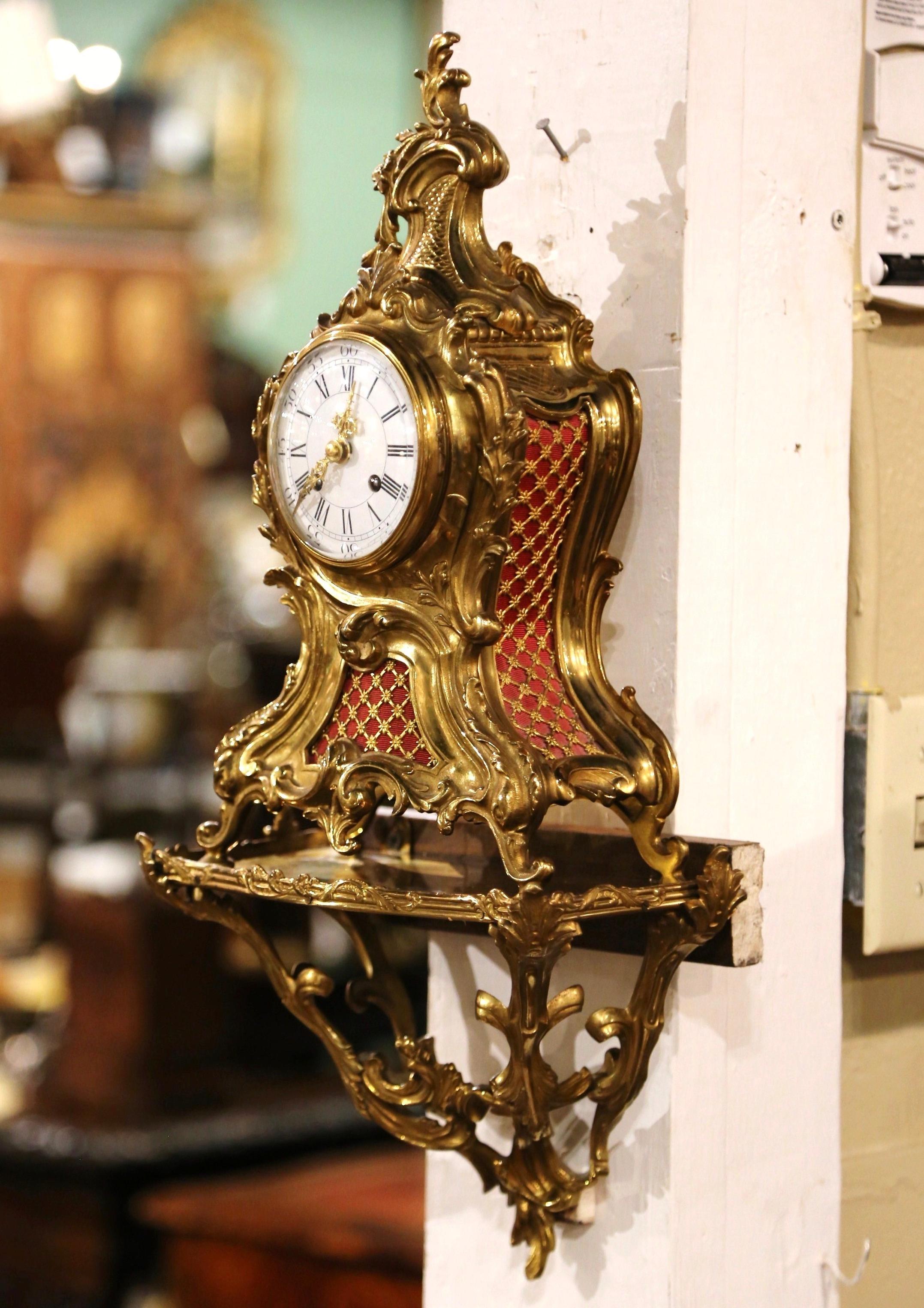 Crafted in Paris, France circa 1860, the antique time keeper can be used as a mantel clock or placed on the original wall bracket; the clock and stand are decorated throughout with foliage, scroll and acanthus leaf motifs. The timepiece is in