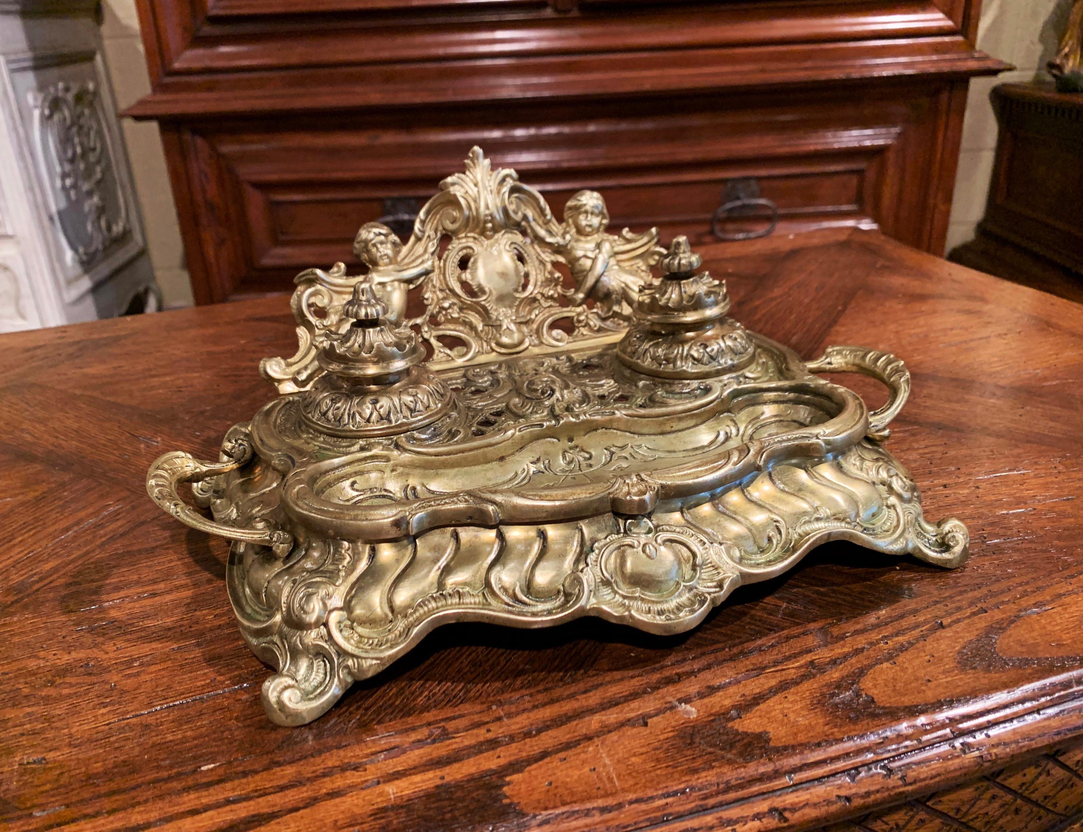 Decorate a man's desk or study with this elegant antique inkwell; crafted in France, circa 1860, the bronze accessory stands on scroll feet over a scalloped apron, and features intricate carvings including a deep curve at the front for pen rest, and
