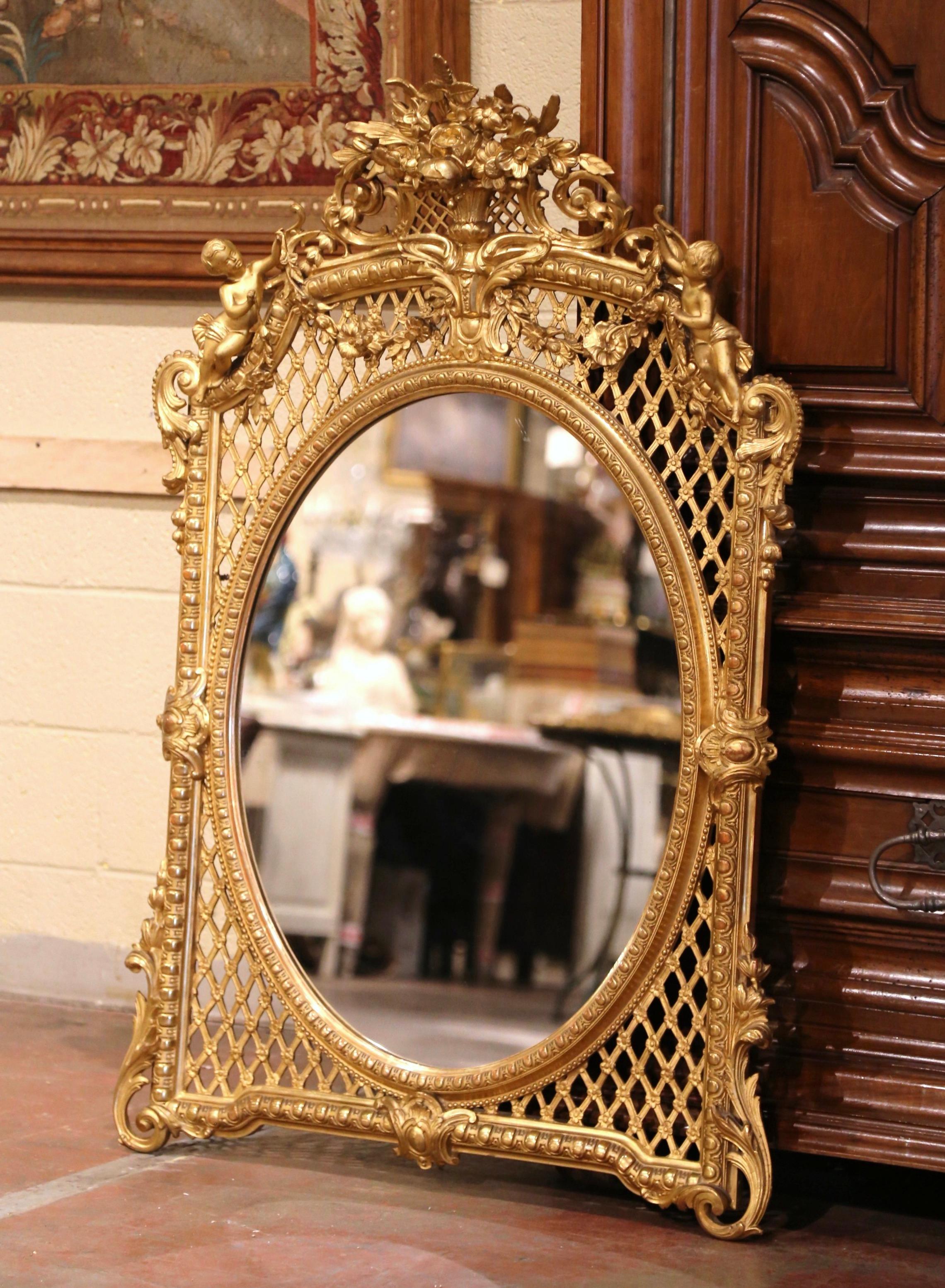 Dress a mantel with this elegant antique gilt mirror. Crafted in Provence, Southern France, circa 1850, and arched at the top, the ornate frame features a pierced floral decor cartouche at the pediment flanked with leaves and foliage motifs and
