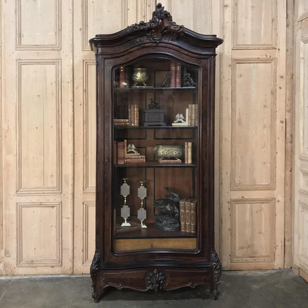 19th century French Louis XV rosewood display armoire ~ bookcase is the perfect choice to display your cherished family heirlooms, special collection, or books in the library! Subtly arched crown is centred with an asymmetrical rococo cartouche, all