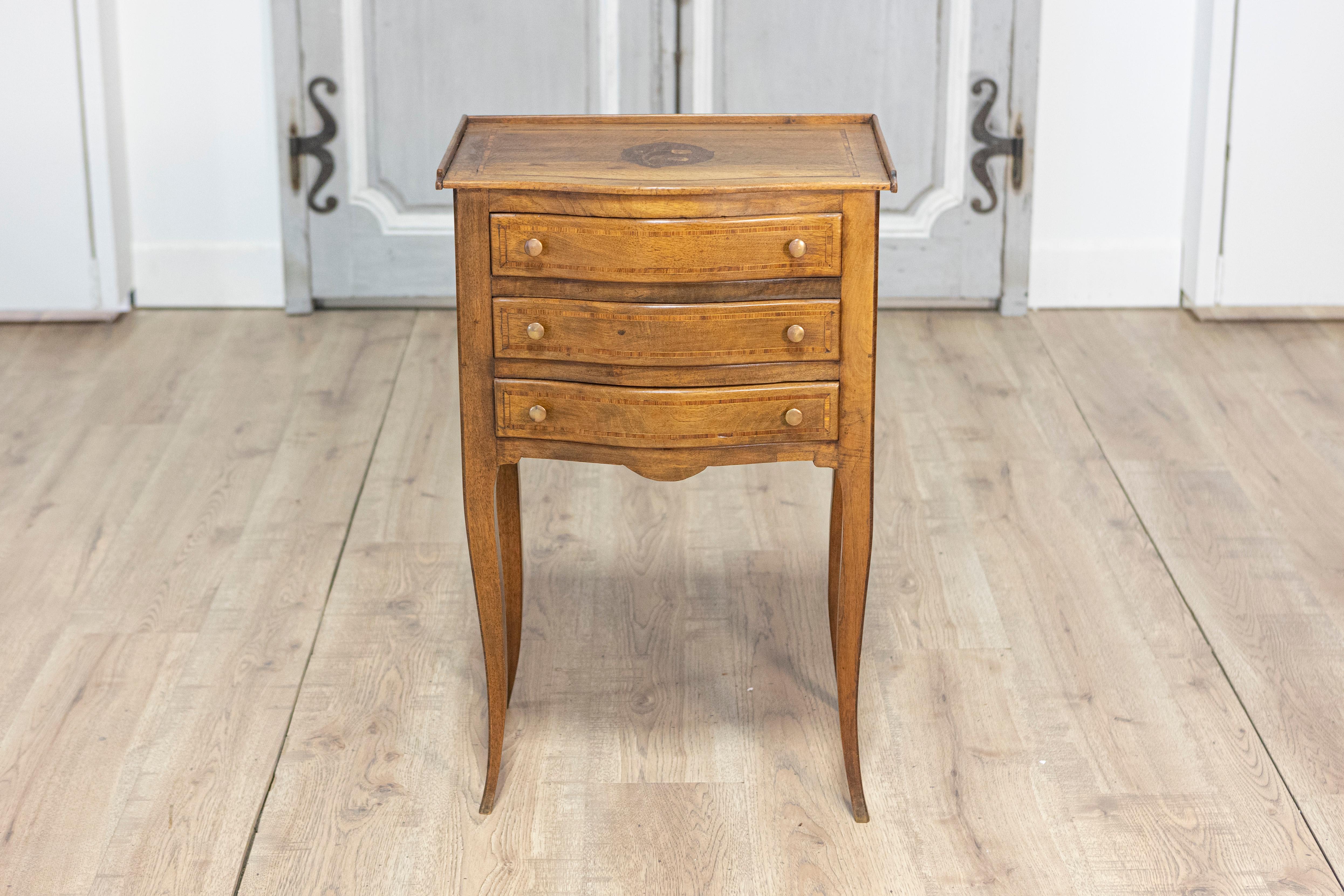 Cette élégante table d'appoint Louis XV française du XIXe siècle, vers 1850, est un exemple raffiné de savoir-faire intemporel et de design classique. Fabriquée en noyer, la table comporte trois tiroirs à façade serpentine ornés de petits boutons en