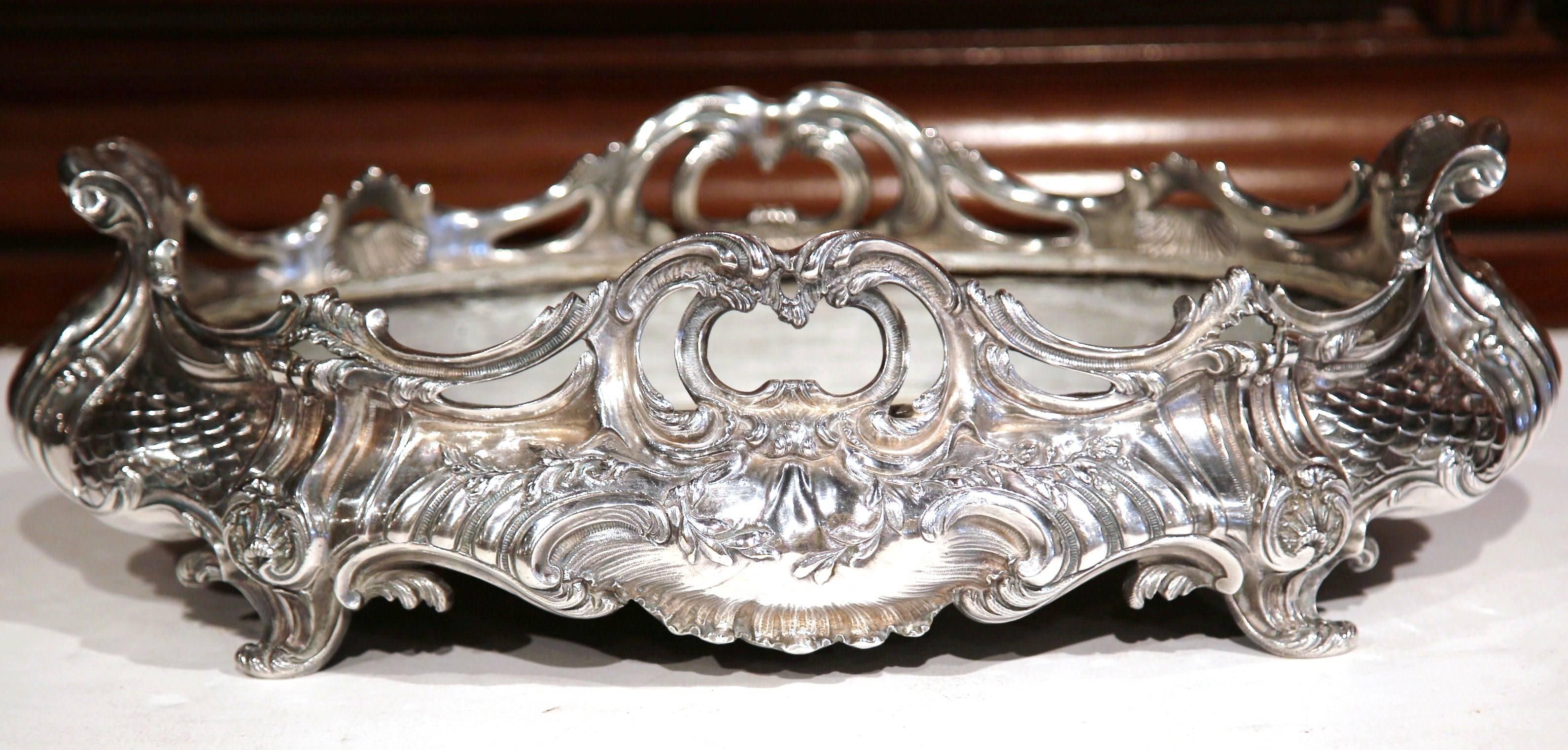 This elegant, silver plated jardinière was created in Paris, France, circa 1850. The large, antique planter sits on four small curved feet and has its original removable zinc liner. Oval in shape, the center piece has elaborate, sculpted motifs