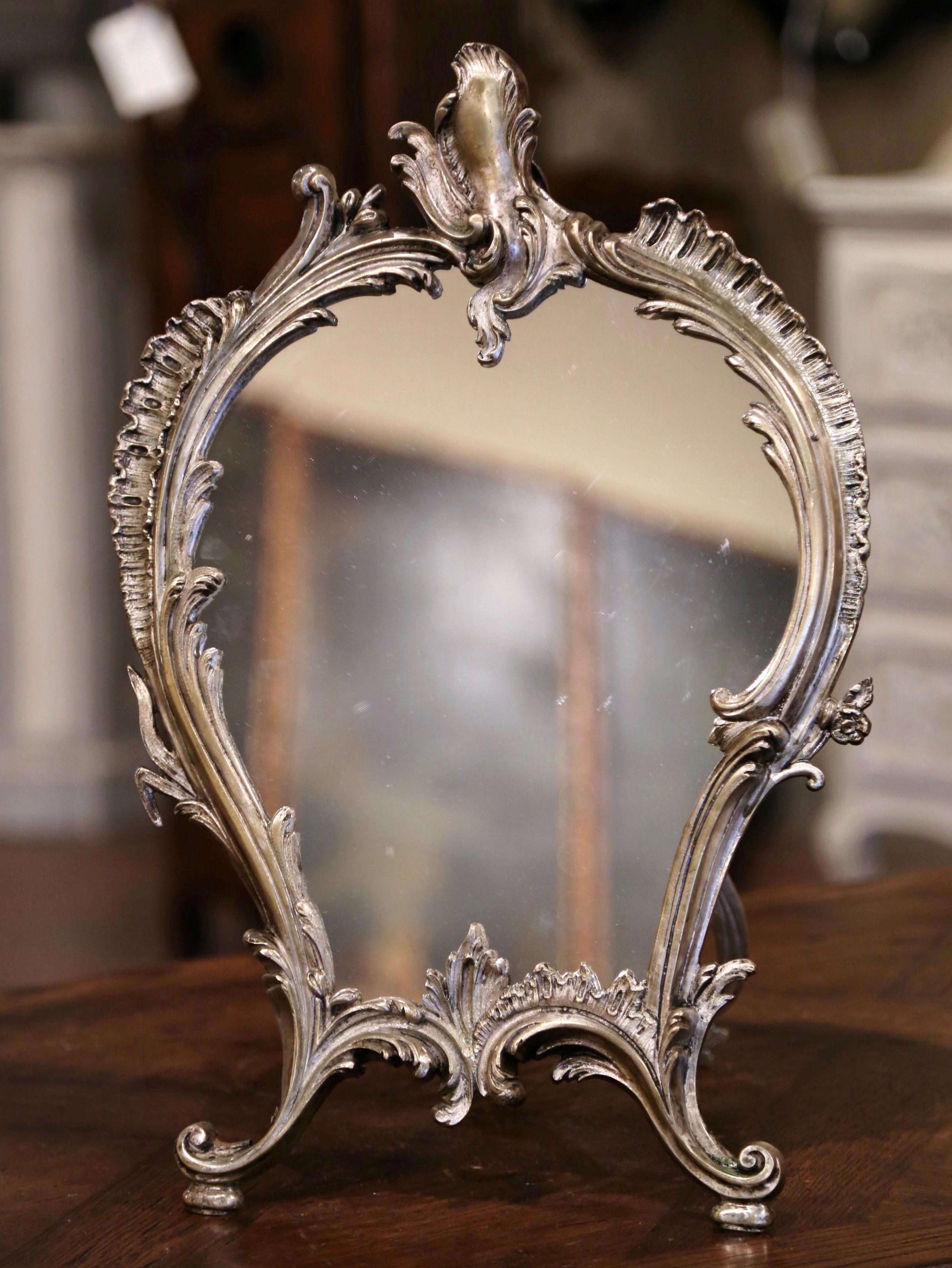 Decorate your master bath counter with this elegant antique dressing mirror. Crafted in France, circa 1870, the bronze table mirror features a centered ornate cartouche, embellished by scrolled floral and leaf decor on both sides, and resting on an