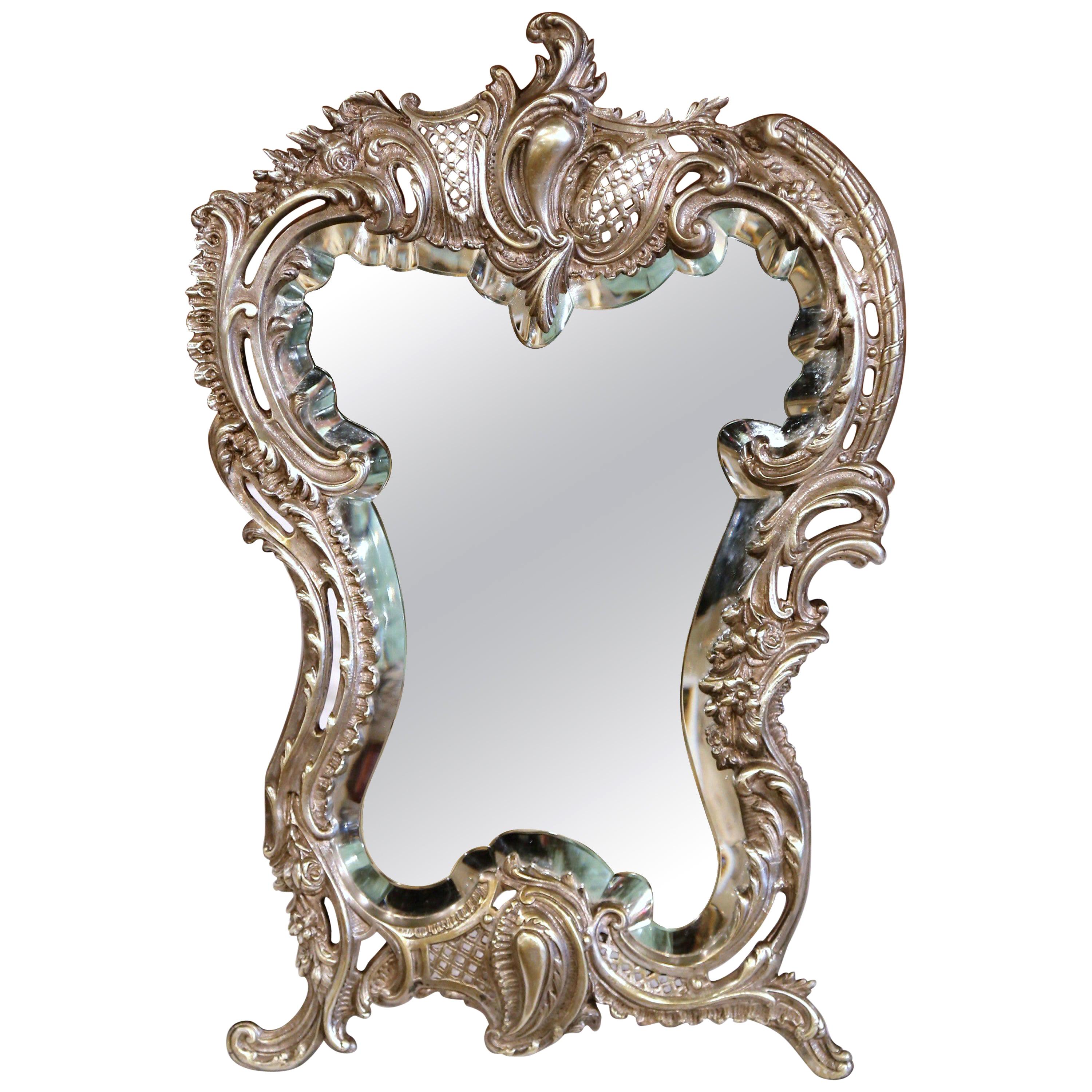 Decorate your master bath counter with this elegant antique dressing mirror. Crafted in France, circa 1870, the freestanding table mirror with the original beveled mercury glass, features a centered ornate cartouche, embellished with scrolled floral