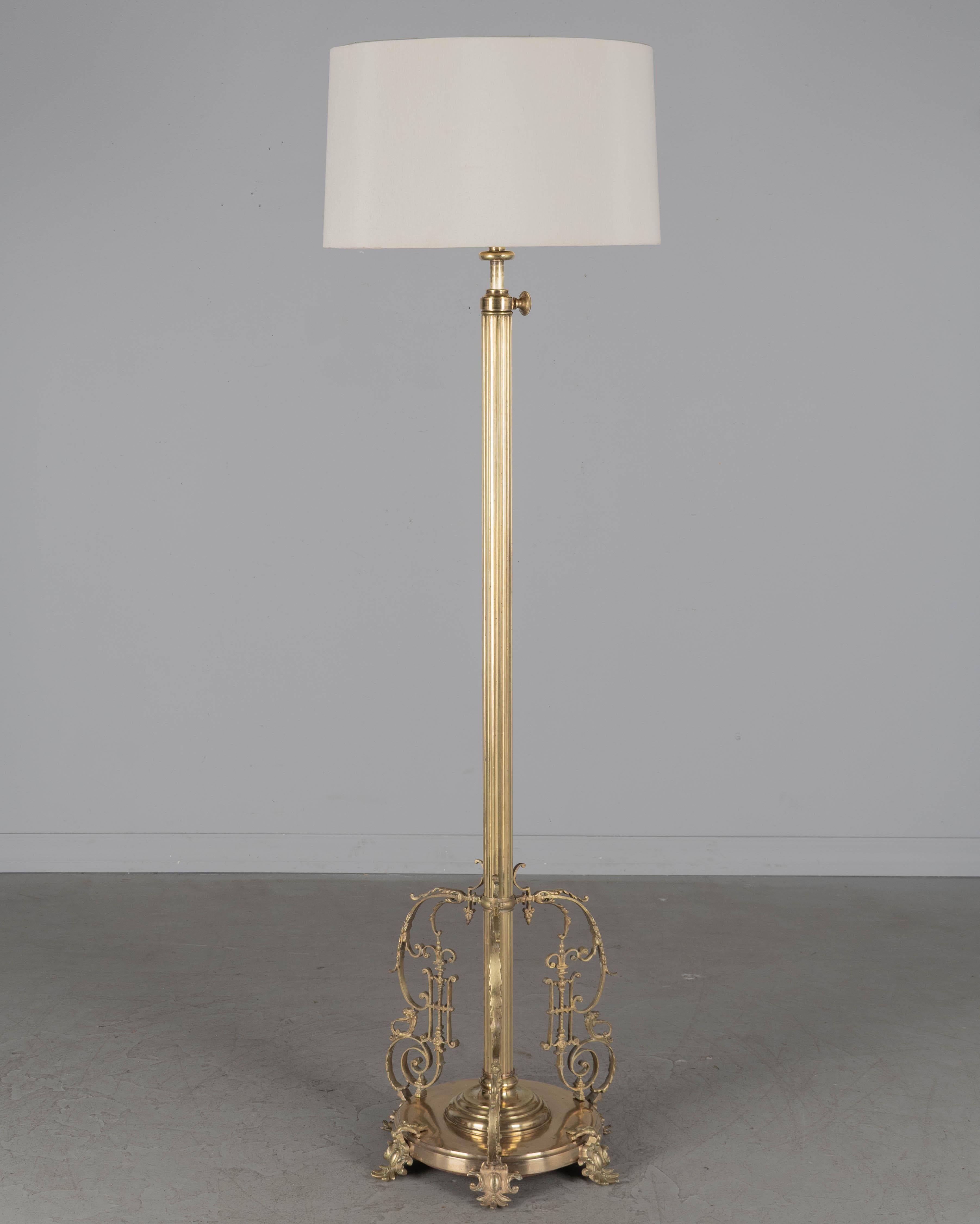 Lámpara de pie francesa de latón estilo Luis XV del siglo XIX. Tres ornamentos decorativos rococó finamente fundidos en la base con seis pies de latón fundido. El mástil de latón estriado con extensión de tubo interior de latón ajusta la altura de