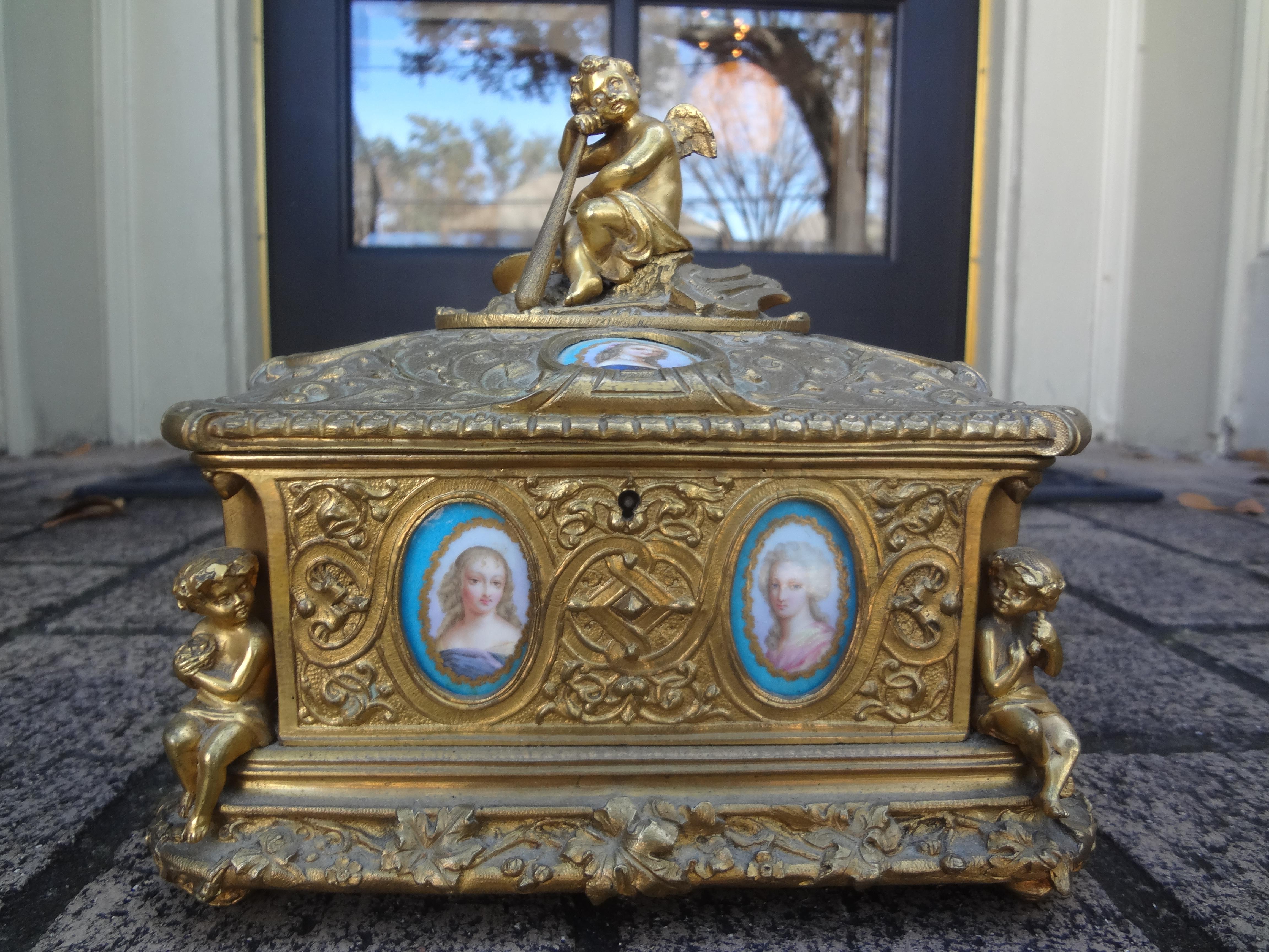 Boîte en bronze de style Louis XV du 19e siècle.
Cette étonnante boîte ancienne en bronze français avec un couvercle à charnière, décorée de cupidons entourés de plaques florales et figuratives en porcelaine de style Sèvres et d'un intérieur doublé