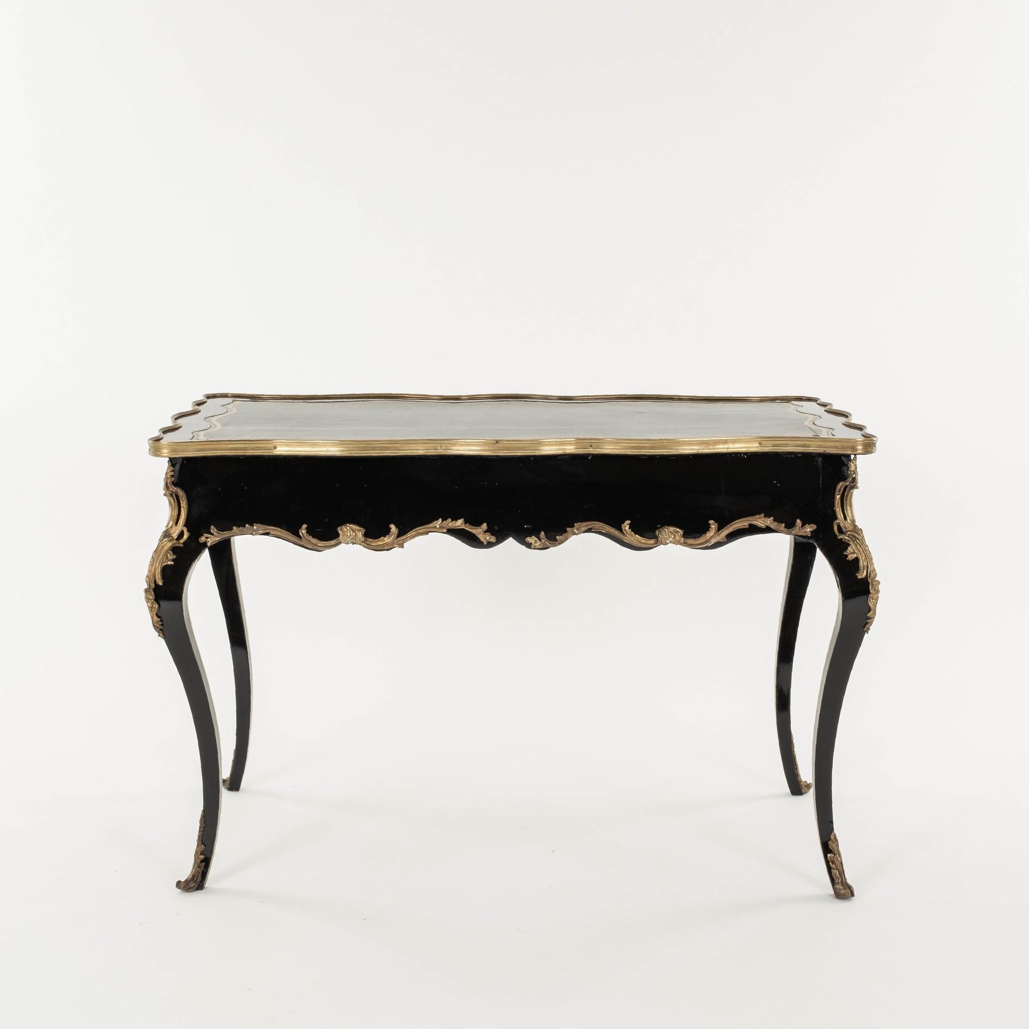 19th Century glossy ebonized Louis XV style bureau plat with lovely bronze ormolu and black leather top with gilded embossing.