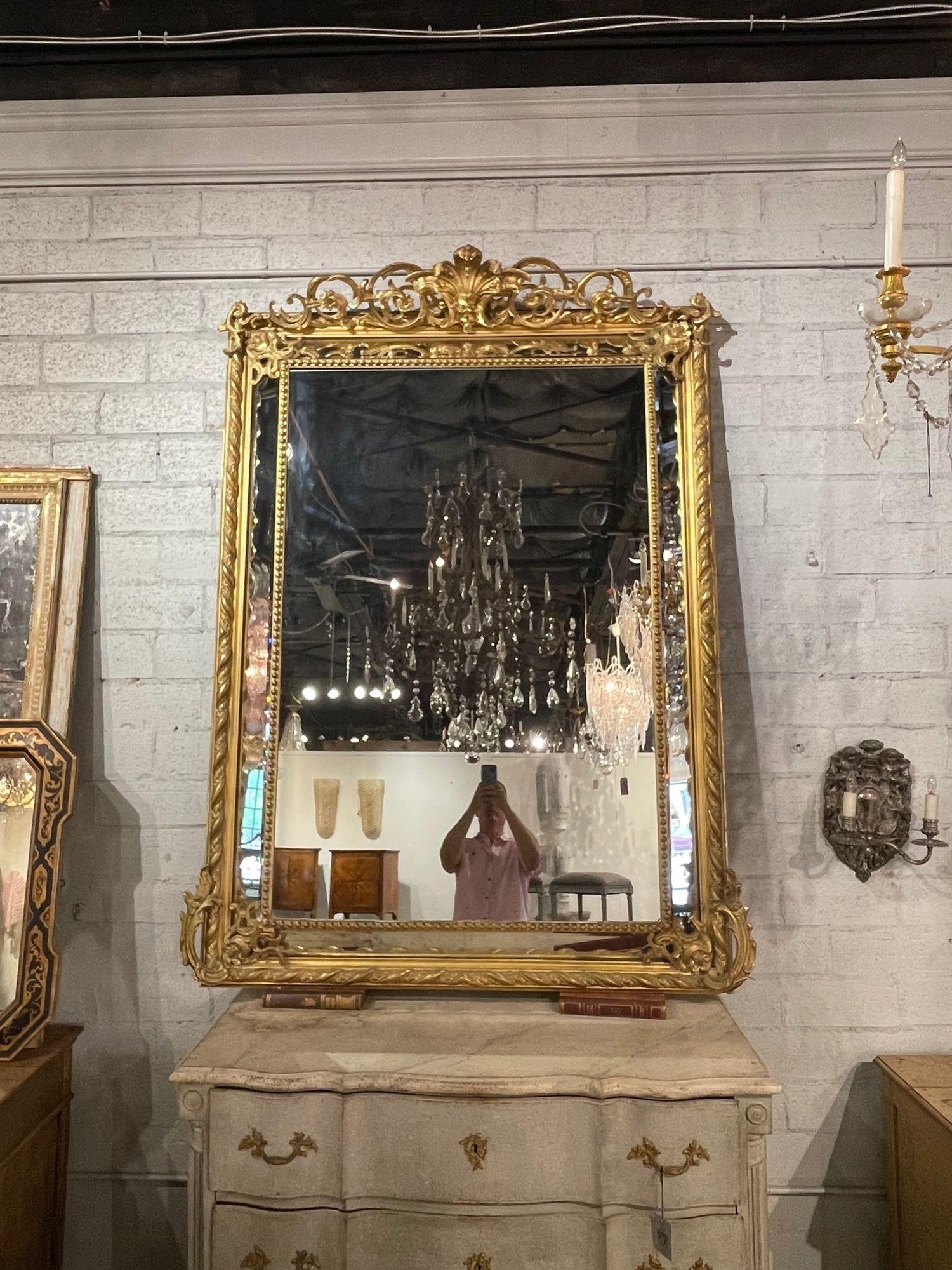 Squisito specchio a cuscino in stile Luigi XV francese del XIX secolo, intagliato e in legno dorato. Caratterizzato da elaborati intagli, tra cui un bellissimo stemma nella parte superiore. Una vera opera d'arte!!!