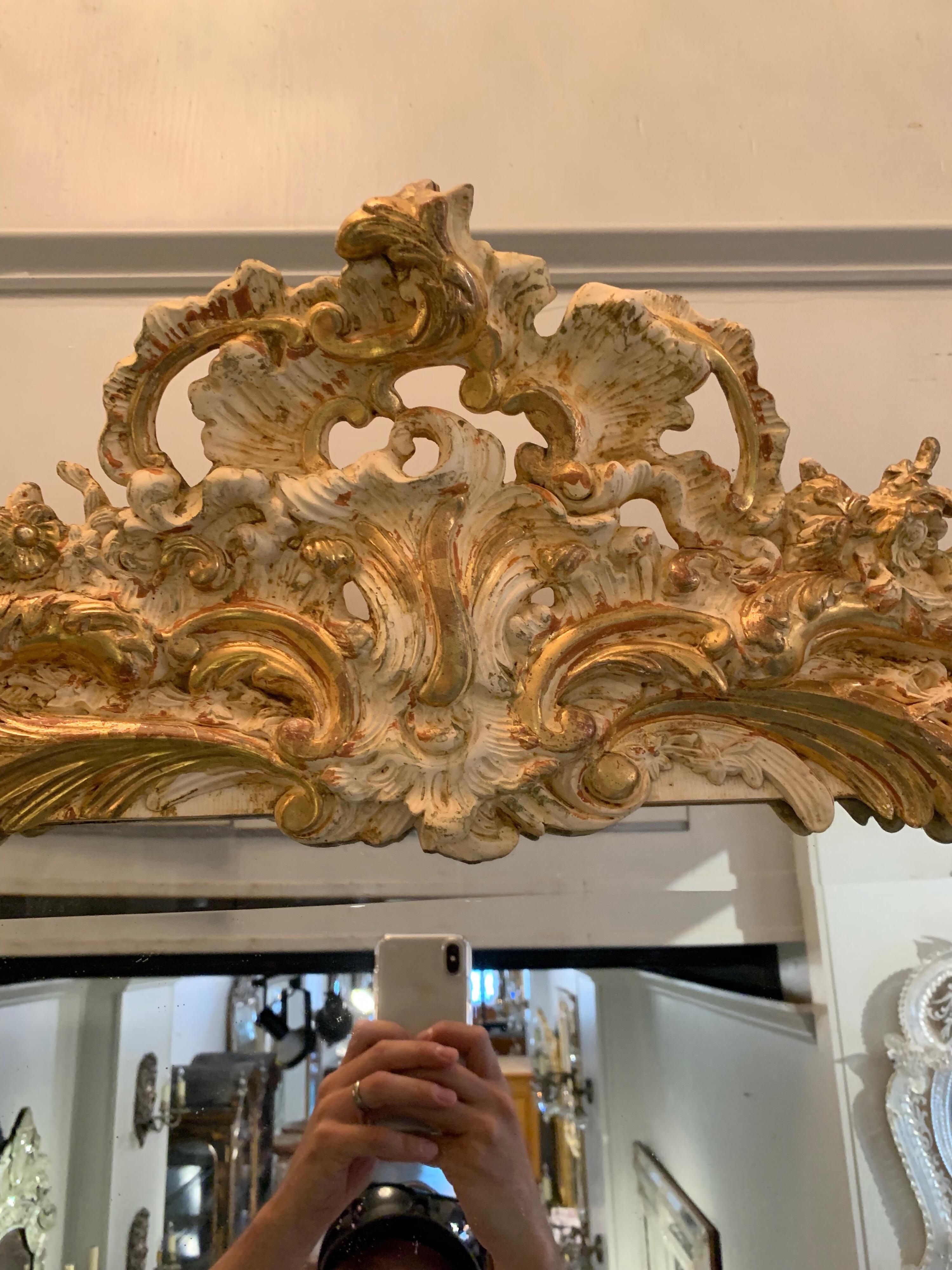 19th century Louis XV Style carved and parcel gilt mirror. Carvings of a shell, leaves and scrolls. An impressive mirror for a fine home.