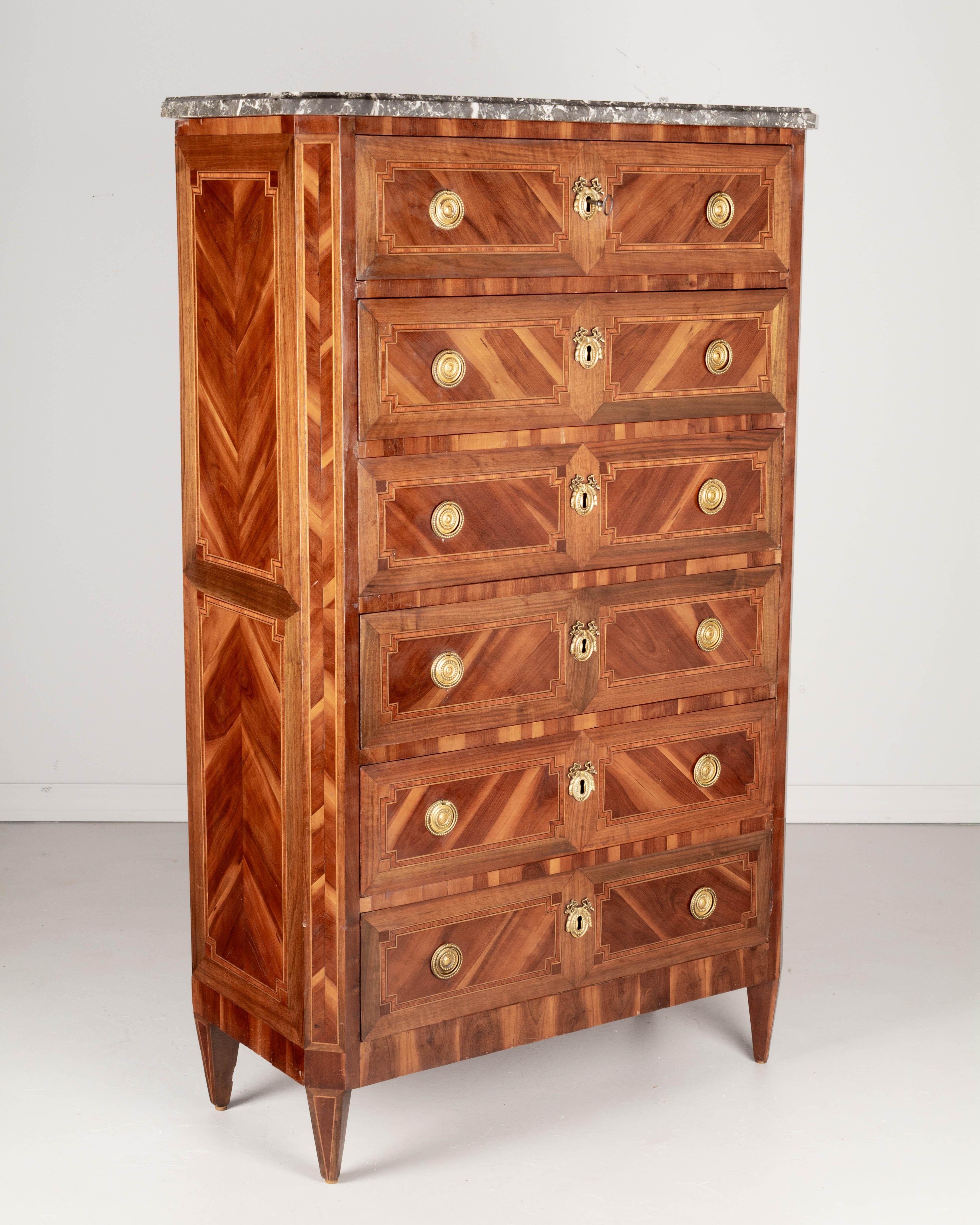 A fine early 19th century Louis XV style French marquetry chiffonier, or tall gentleman's chest. Expertly crafted with inlaid veneers of walnut and mahogany and various exotic woods. Oak as a secondary wood. Finish retains a nice luster. Six