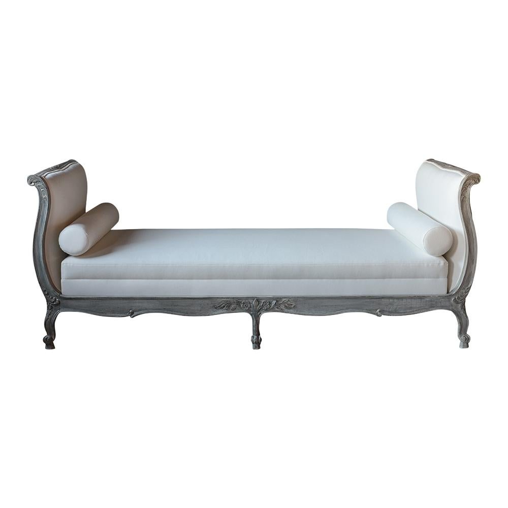 This Late 19th Century Louis XV Daybed has been completely restored, is made out of walnut wood and has been newly painted in a pale gray & off-white color combination with a distressed finish. This Daybed features a hand-crafted wooden frame,