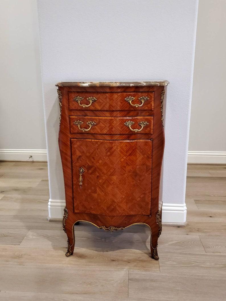 An exceptional French side cabinet from the late 19th century. Likely Parisian in origin, elegantly refined, finished in the luxurious and sophisticated Louis XV taste, presenting with the striking original decoratively shaped variegated specimen