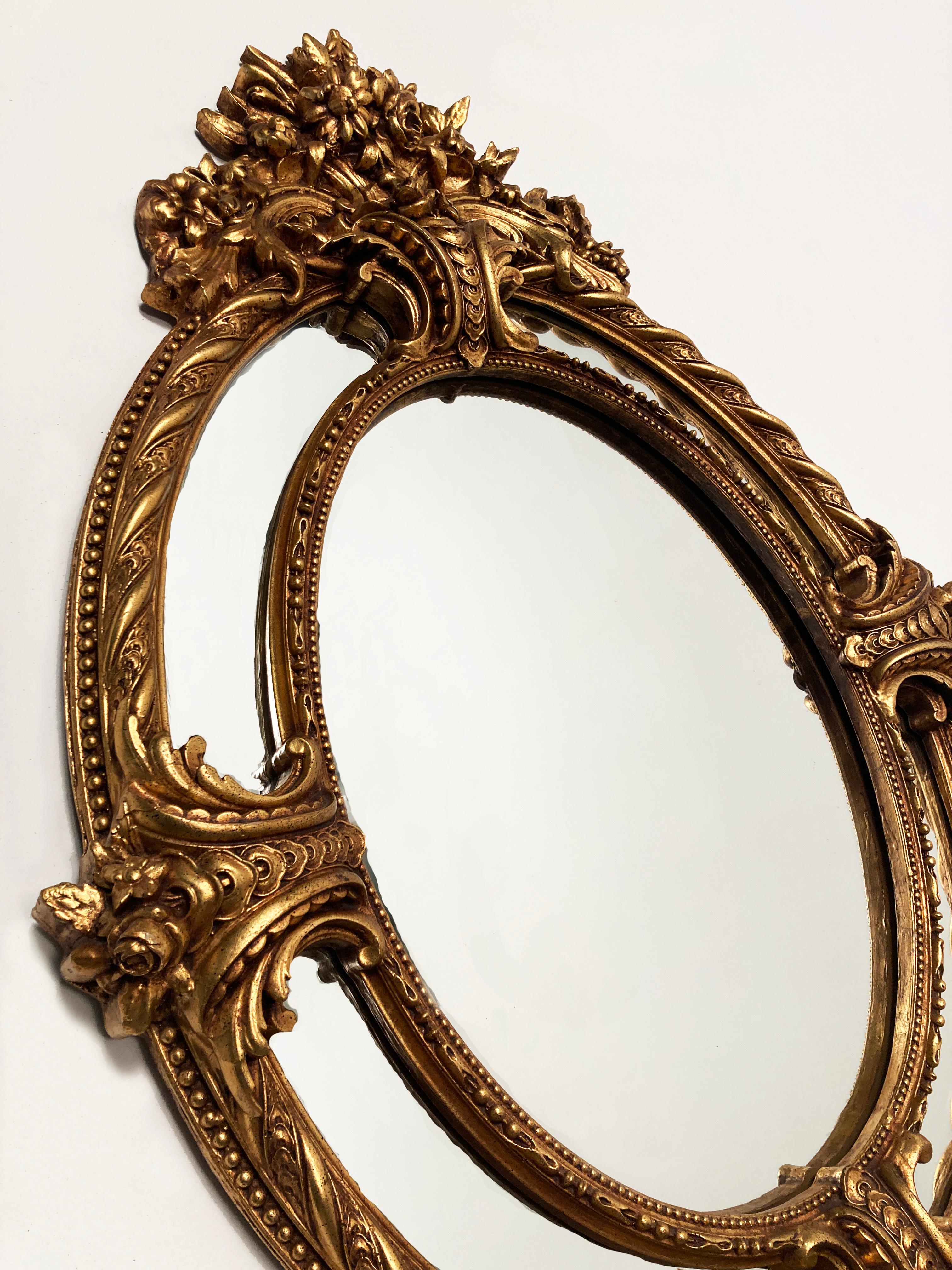 If you have been searching for that statement piece in a hall or over a particular furniture arrangement, look no further. This is a most stunning example of elegance. This is a French Louis XV style gilt carved oval mirror with bouquet of flowers