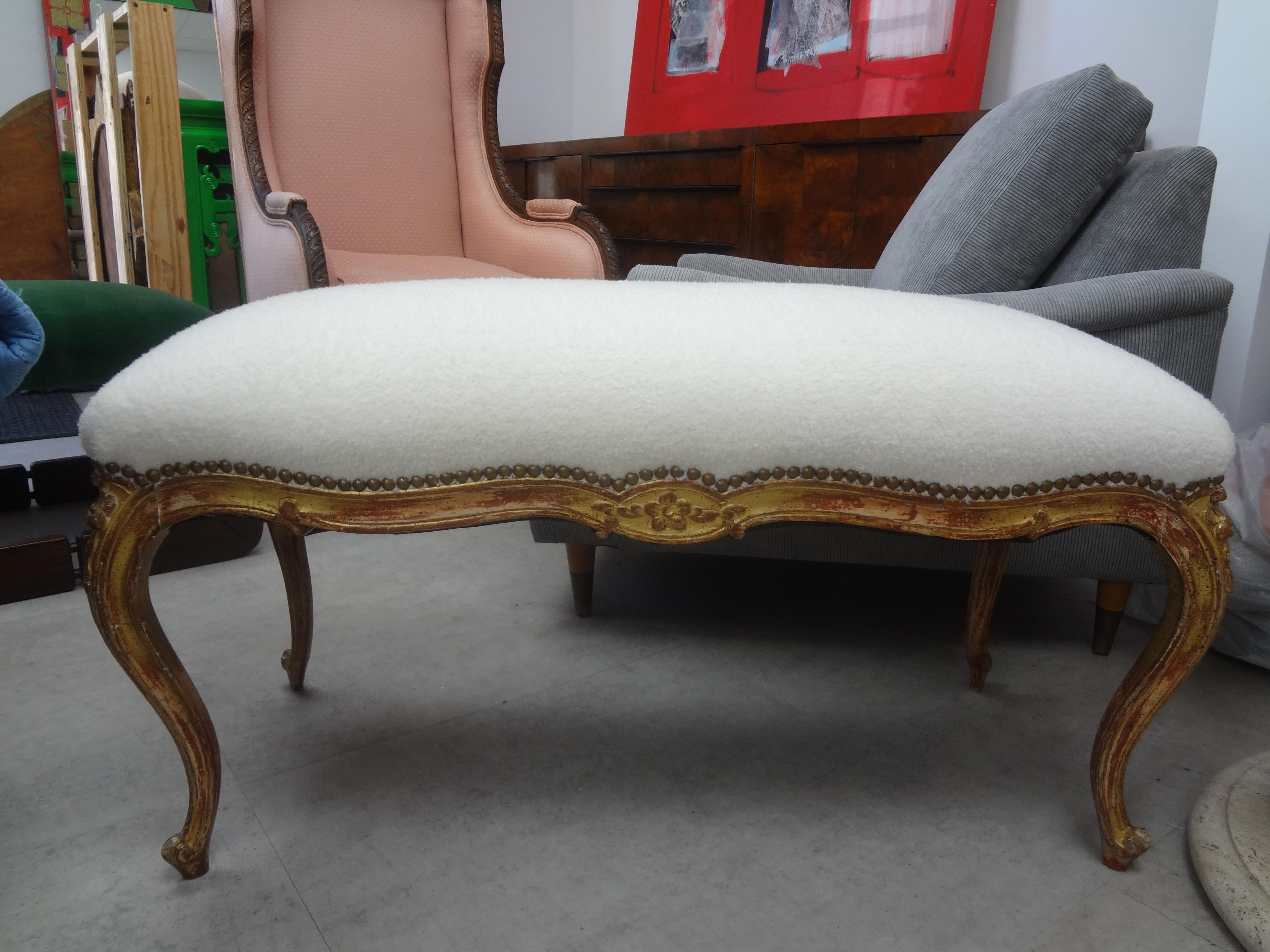 19th century French Louis XV style giltwood bench. This stunning antique French gilt wood bench has excellent patina and has been professionally upholstered in plush white velvet with brass nail head detail.