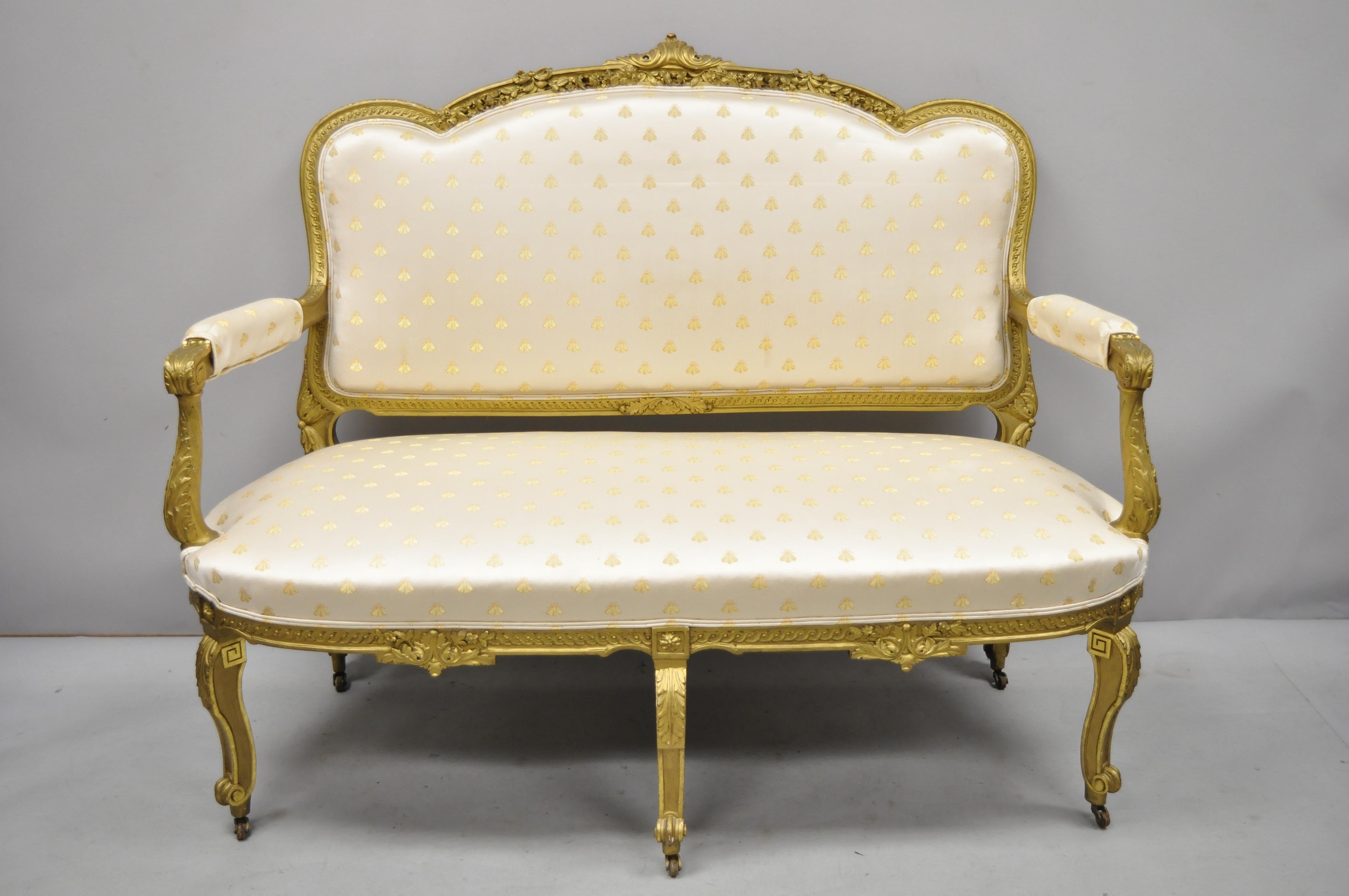 19th century French Louis xv style gold giltwood 3-piece parlor salon suite. Set includes, (1) loveseat, (1) armchair, (1) side chair. All chairs feature gold silk upholstery with embroidered bees, floral and scrollwork carved frames, gold gilt