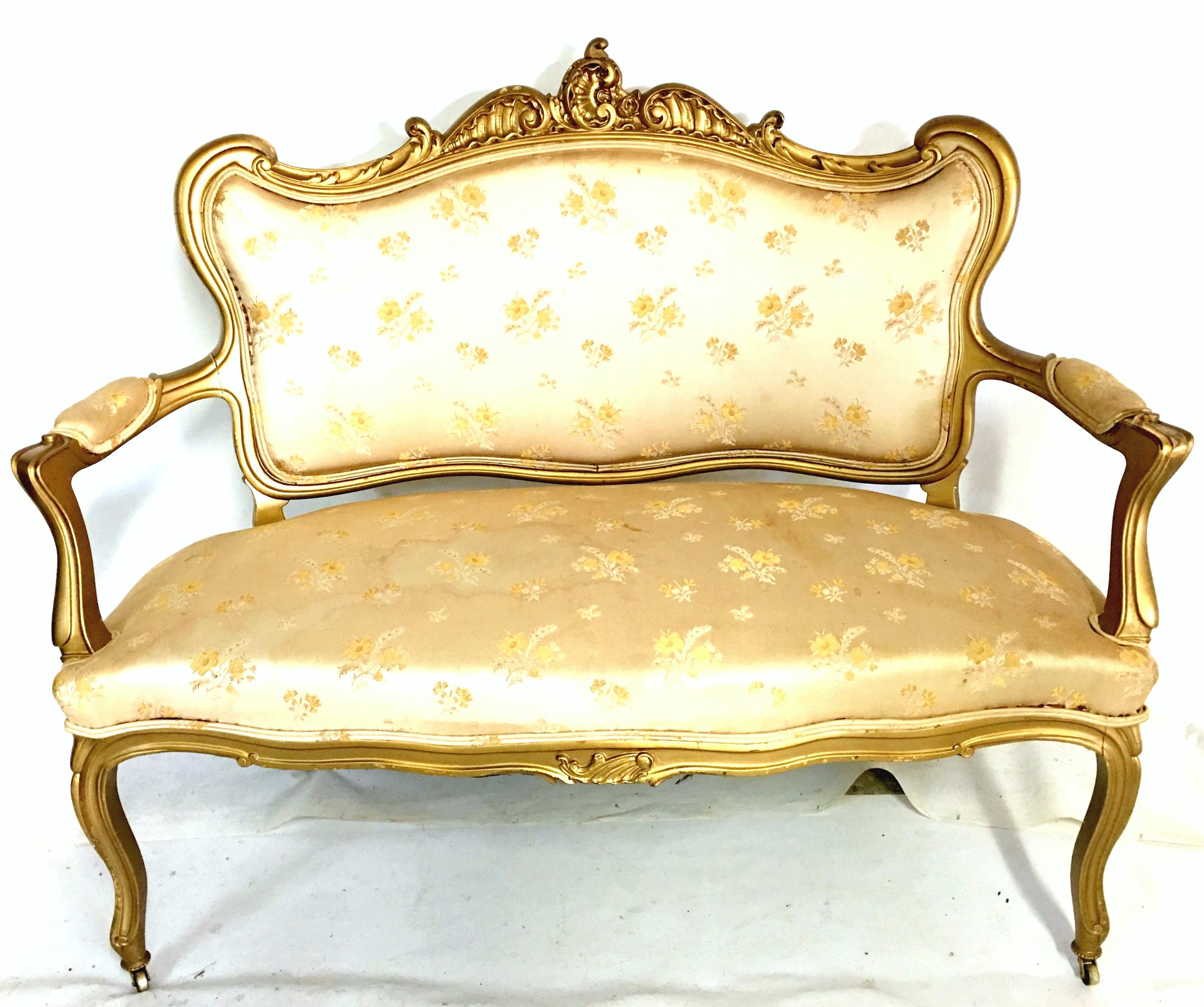 19th century French Louis XV style gilt gold beech wood three-piece parlor set. This French hand carved beech wood parlor set procured from a French estate, maintains the original and authentic hand painted 24-karat gold gilt under gold over paint.